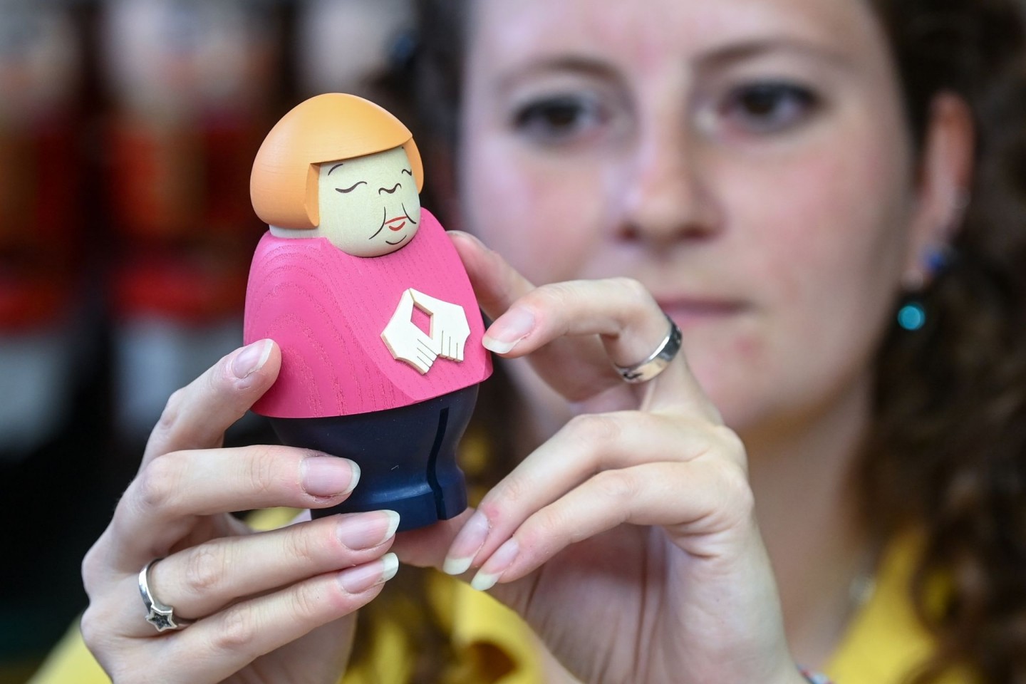 Sina Klement komplettiert in der Schauwerkstatt der Seiffener Volkskunst in Seiffen eine Merkel-Figur.