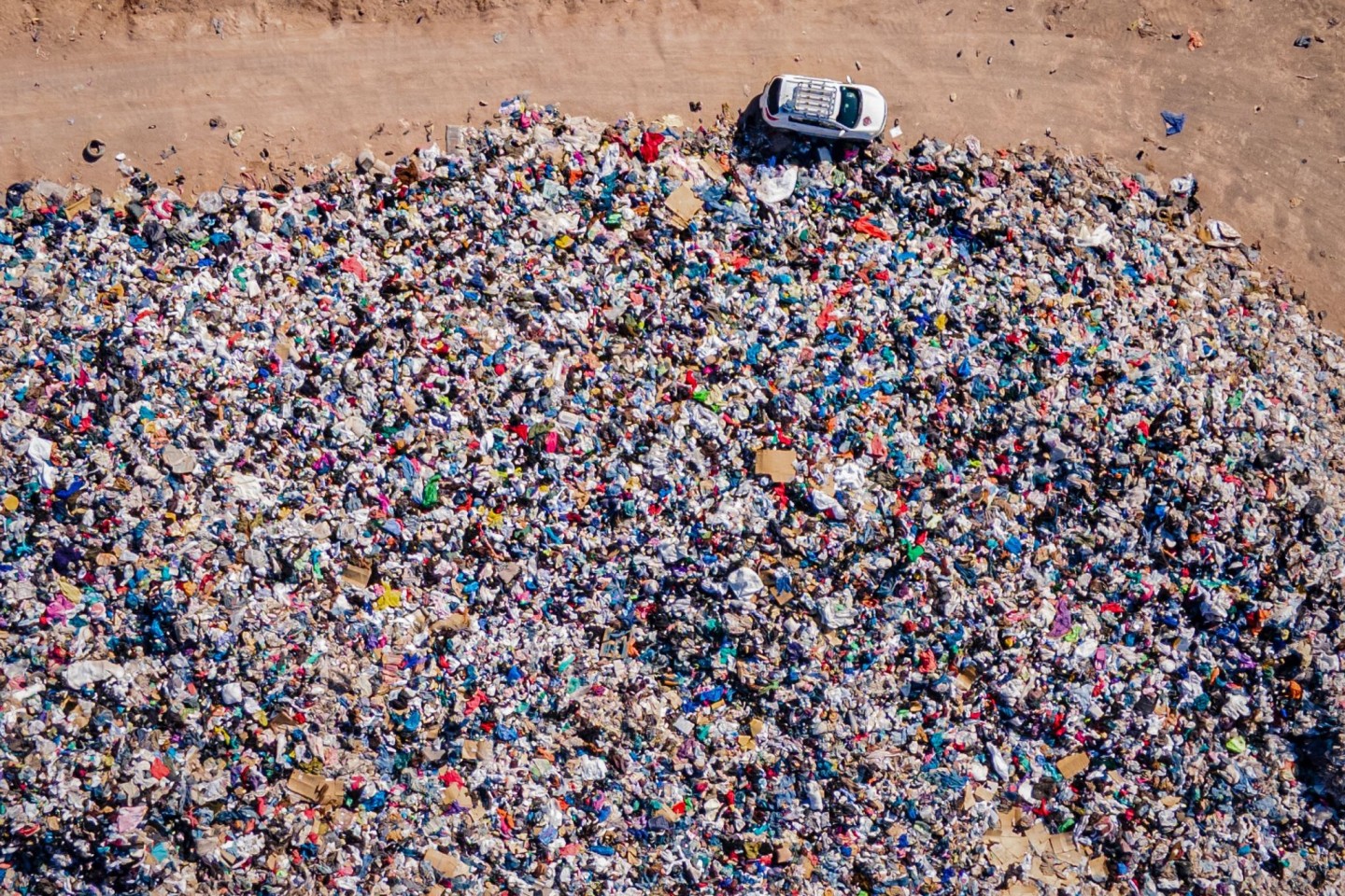 Gebrauchte Kleidungsstücke liegen der Müll-Deponie in der Wüste.