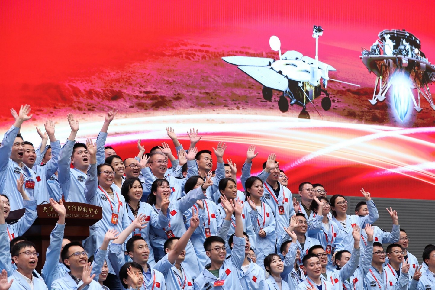 Technisches Personal im Pekinger Raumfahrtkontrollzentrum feiert die erfolgreiche Landung der chinesischen Sonde Tianwen-1 auf dem Mars.