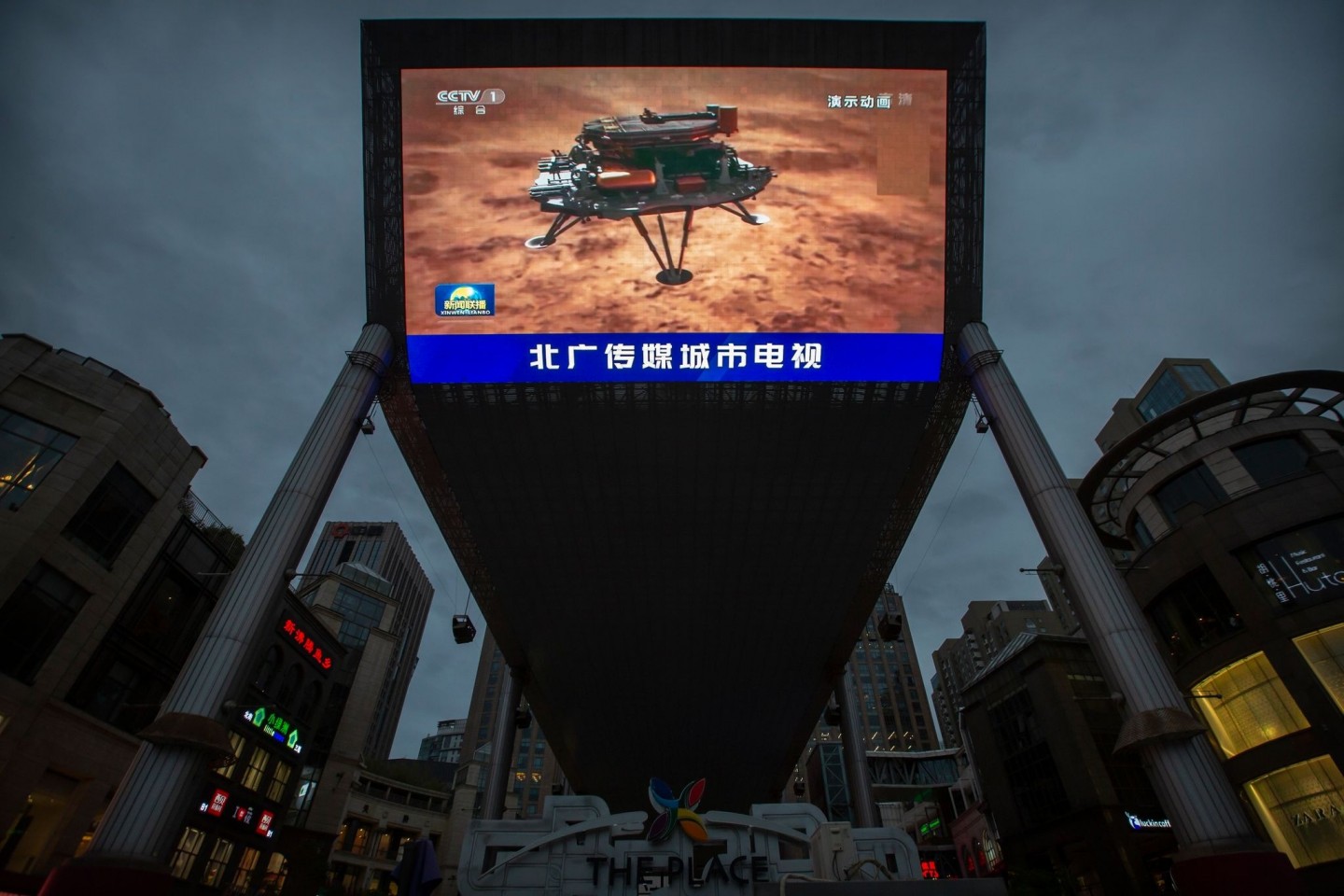 Feiertag für das chinesische Staatsfernsehen: Eine Nachrichtensendung über die erfolgreiche Landung einer Sonde auf dem Mars wird auf einem großen Videobildschirm gezeigt.
