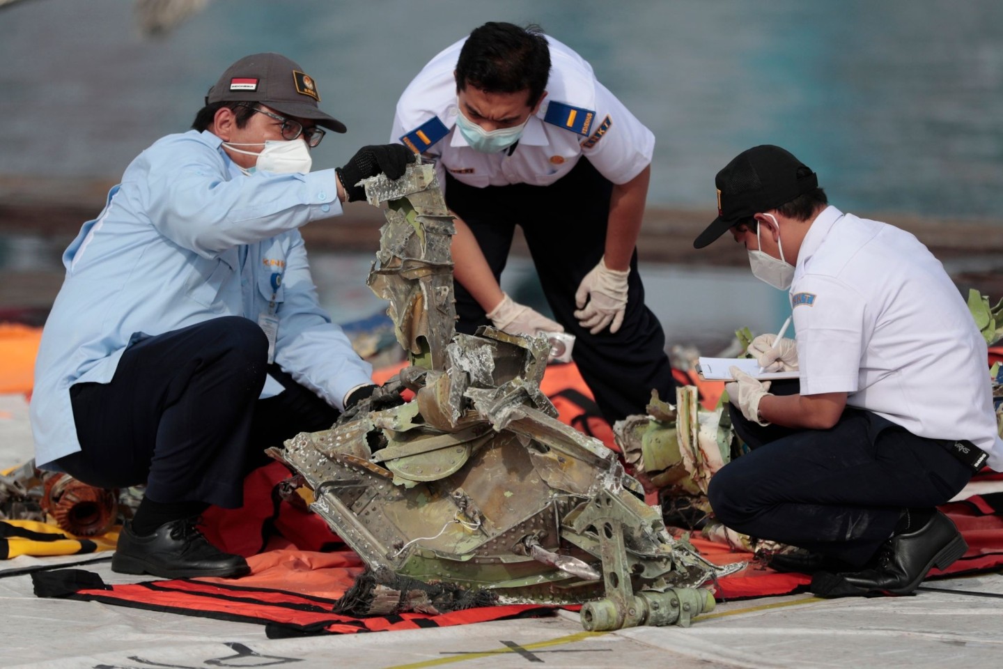 Ermittler inspizieren ein Wrackteil des Sriwijaya Air Flugzeugs SJ-182. Die Überreste wurden aus der Javasee geborgen, wo das Passagierflugzeug am 09.01.2021 abgestürzt war. (Archivbild)