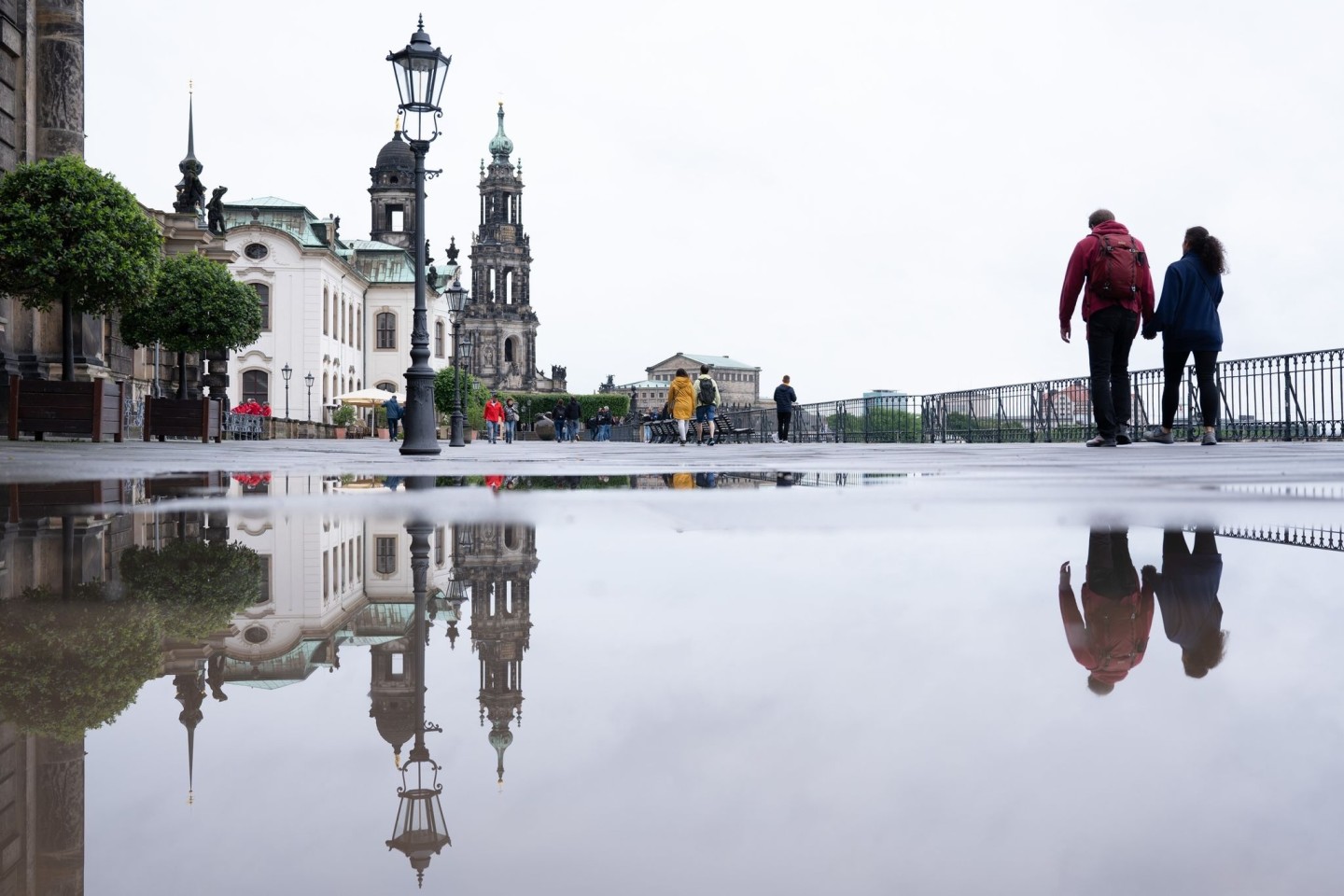 Regen in Dresden: Das Ständehaus (l-r), die Katholische Hofkirche und die Semperoper spiegeln sich in einer Regenpfütze.