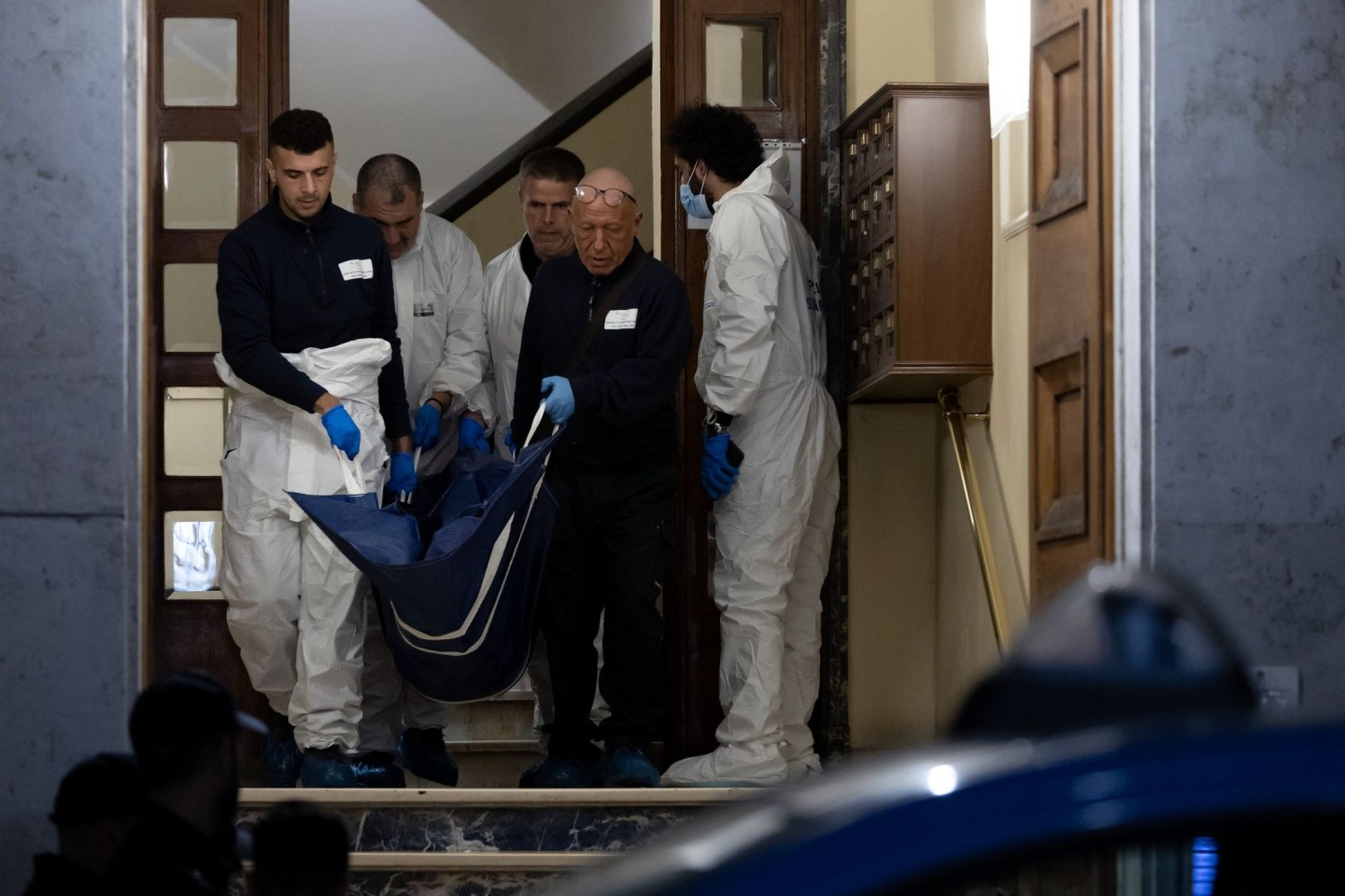 Einsatzkräfte der Polizei tragen einen Leichnam aus einem Haus. In Rom sind drei Prostituierte an einem Tag getötet worden.