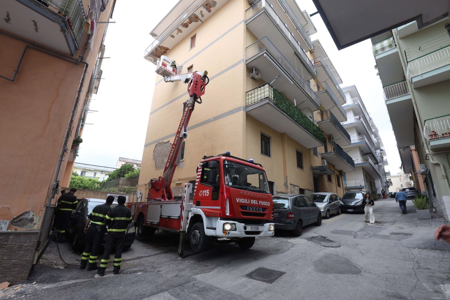 Von einem Hubwagen aus inspiziert ein Feuerwehrmann Schäden an einem Gebäude in Pozzuoli.