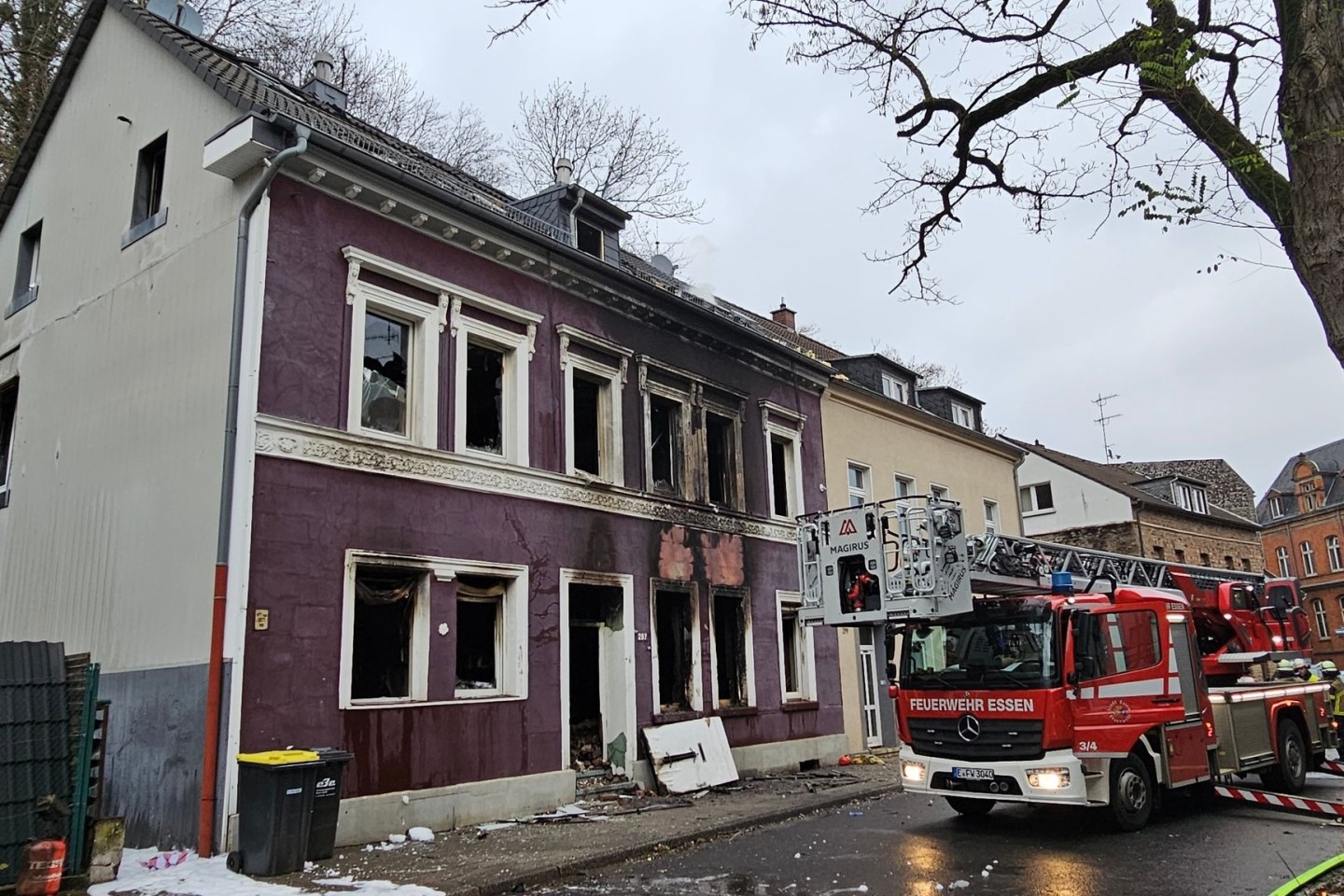 Ein Feuerwehrauto steht nach der Explosion in einem Mehrfamilienhaus vor dem zerstörten Gebäude.