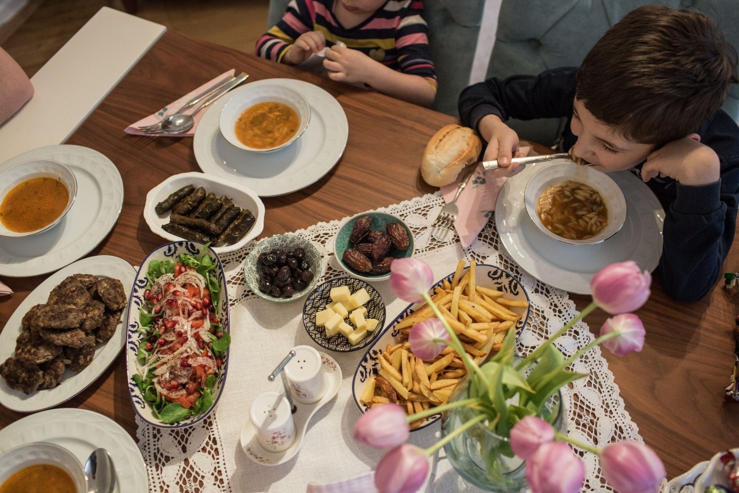 Kinder und Eltern nehmen während des heiligen Fastenmonats Ramadan ein gemeinsames Fastenbrechen-Essen in ihrer Wohnung ein.