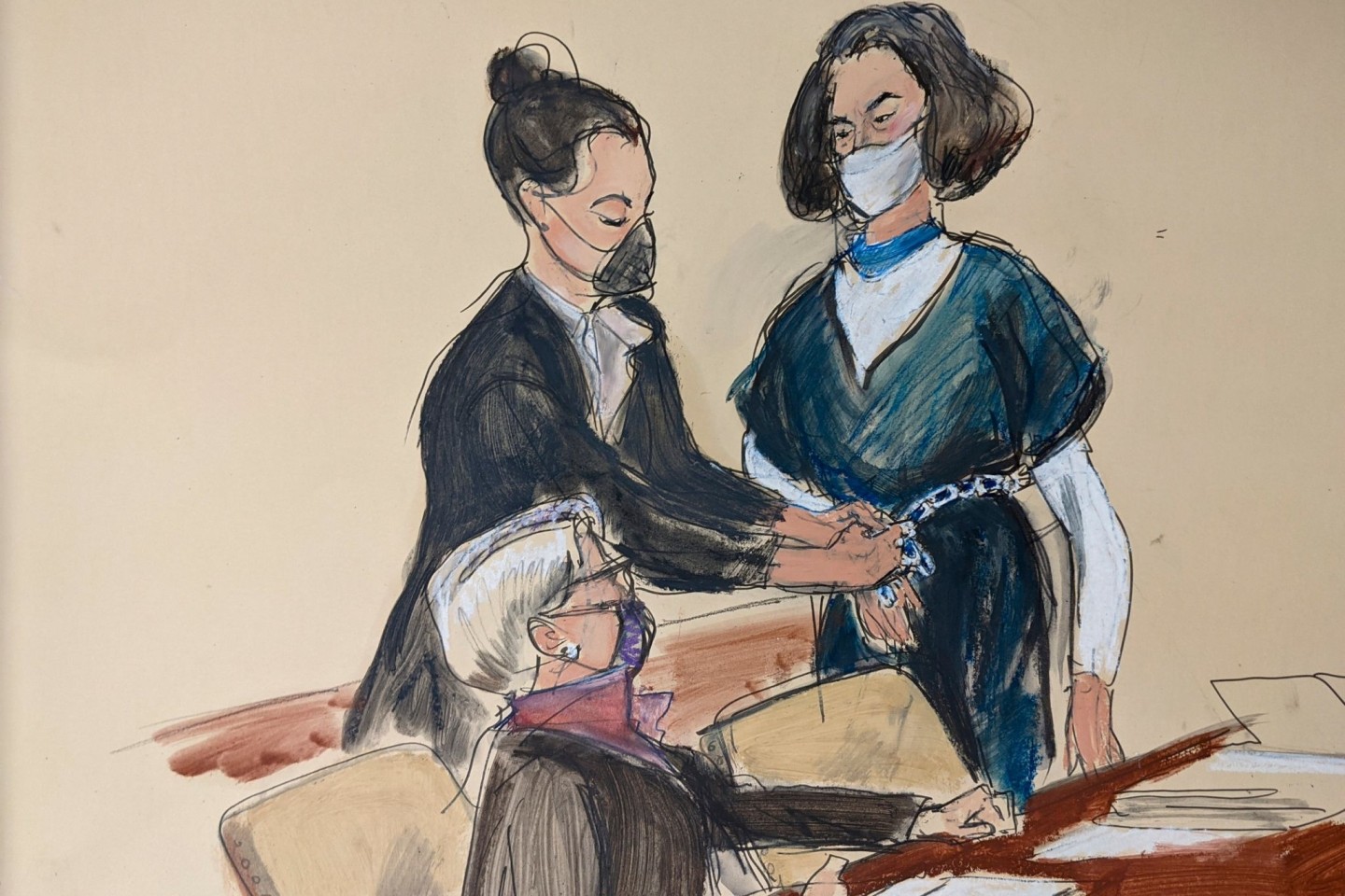 Auf dieser Gerichtsskizze steht Ghislaine Maxwell vor ihrer Anwältin Bobbi Sternheim, während eine Gerichtsangestellte ihr vor einer Anhörung die Fesseln abnimmt.