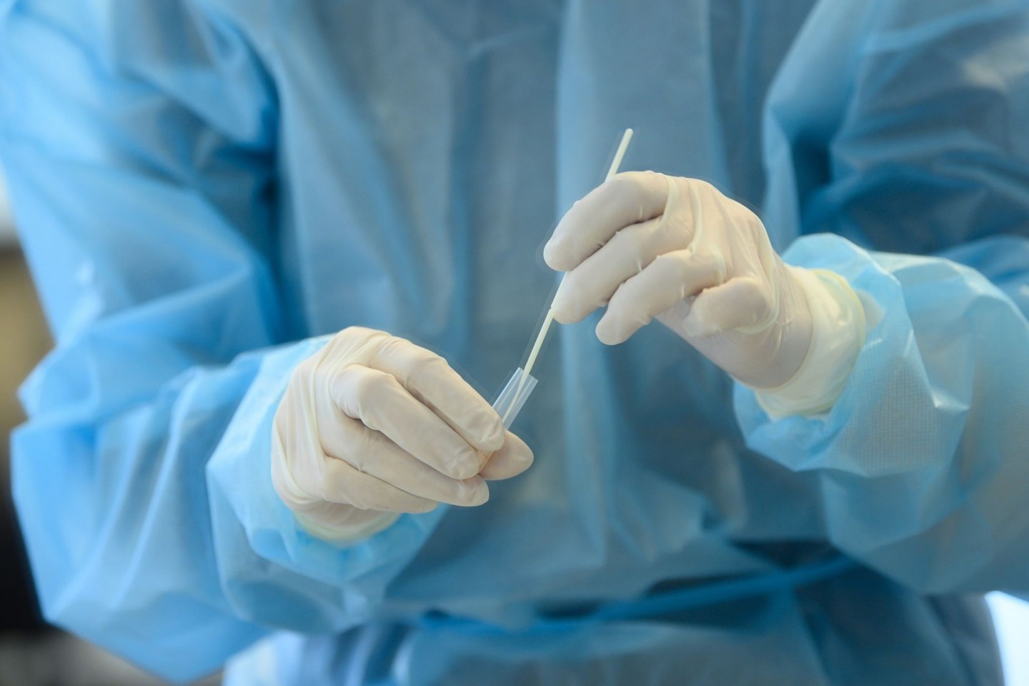 Eine medizinische Mitarbeiterin entnimmt eine Nasenabstrichprobe für einen Coronatest.
