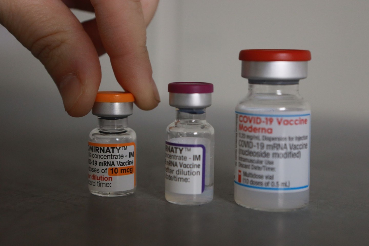 Flaschen mit den Impfstoffen Comirnaty und Moderna stehen in einem Impfstofflager.