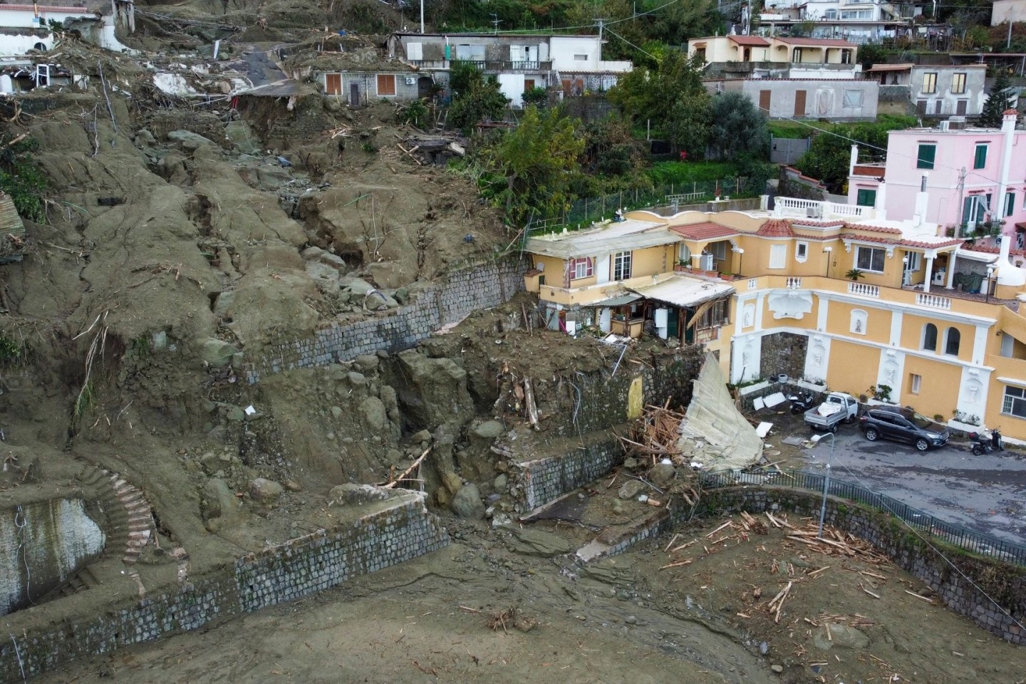 Eine Luftaufnahme zeigt Häuser, die durch das Unwetter und die einhergehenden Erdrutsche beschädigt wurden. Die Folgen des Unwetters kosteten mehrere Menschen das Leben.