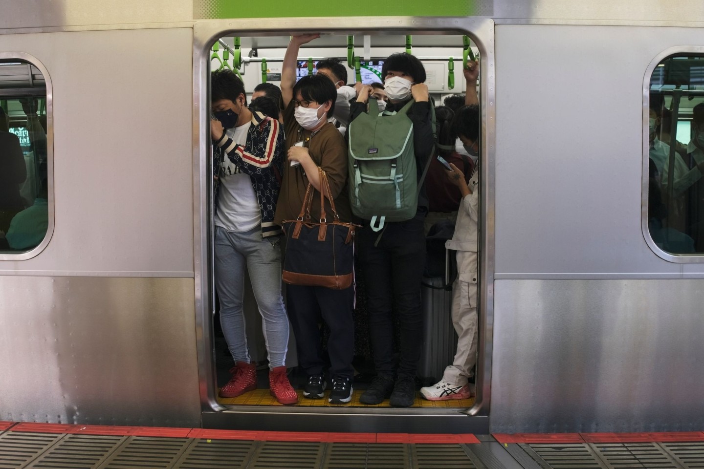 Pendler drängen sich in Tokio in einen Waggon (Symbolbild).