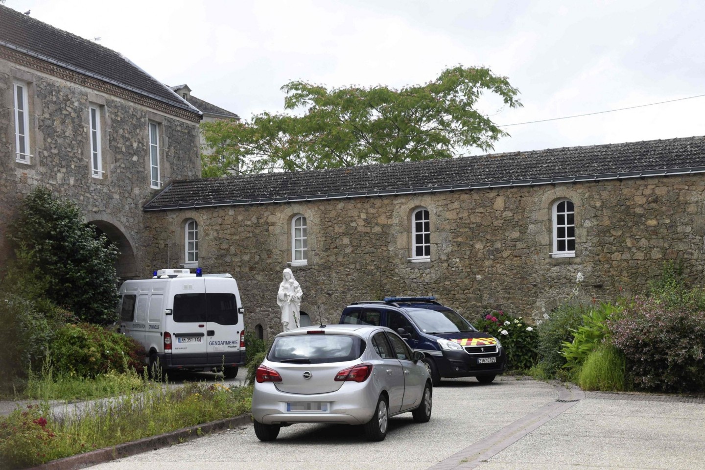 Fahrzeuge der Gendarmerie parken in Saint-Laurent-sur-Sèvre, wo der katholische Priester getötet wurde.
