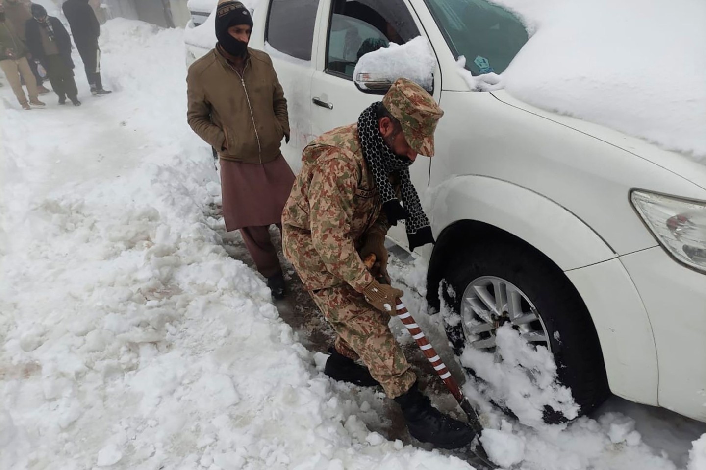 Nichts geht mehr, ein Soldat hilft: Nach einem heftigen Wintereinbruch im Norden Pakistans sind mindestens 21 Urlauber ums Leben gekommen.