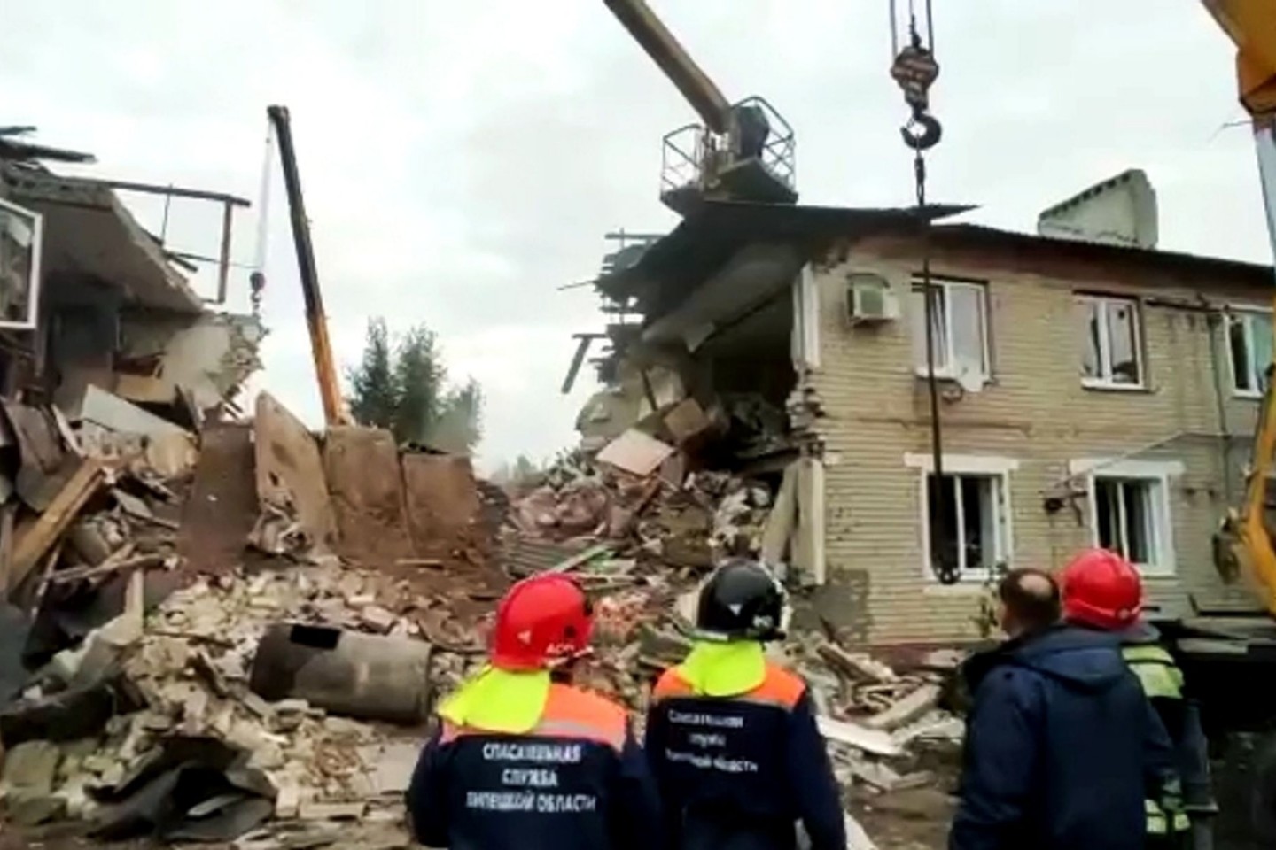 Das Standbild aus einem Video des russischen Katastrophenschutzministeriums zeigt Rettungskräfte vor einem nach einer Gasexplosion zerstörten zweistöckigen Wohnhaus.