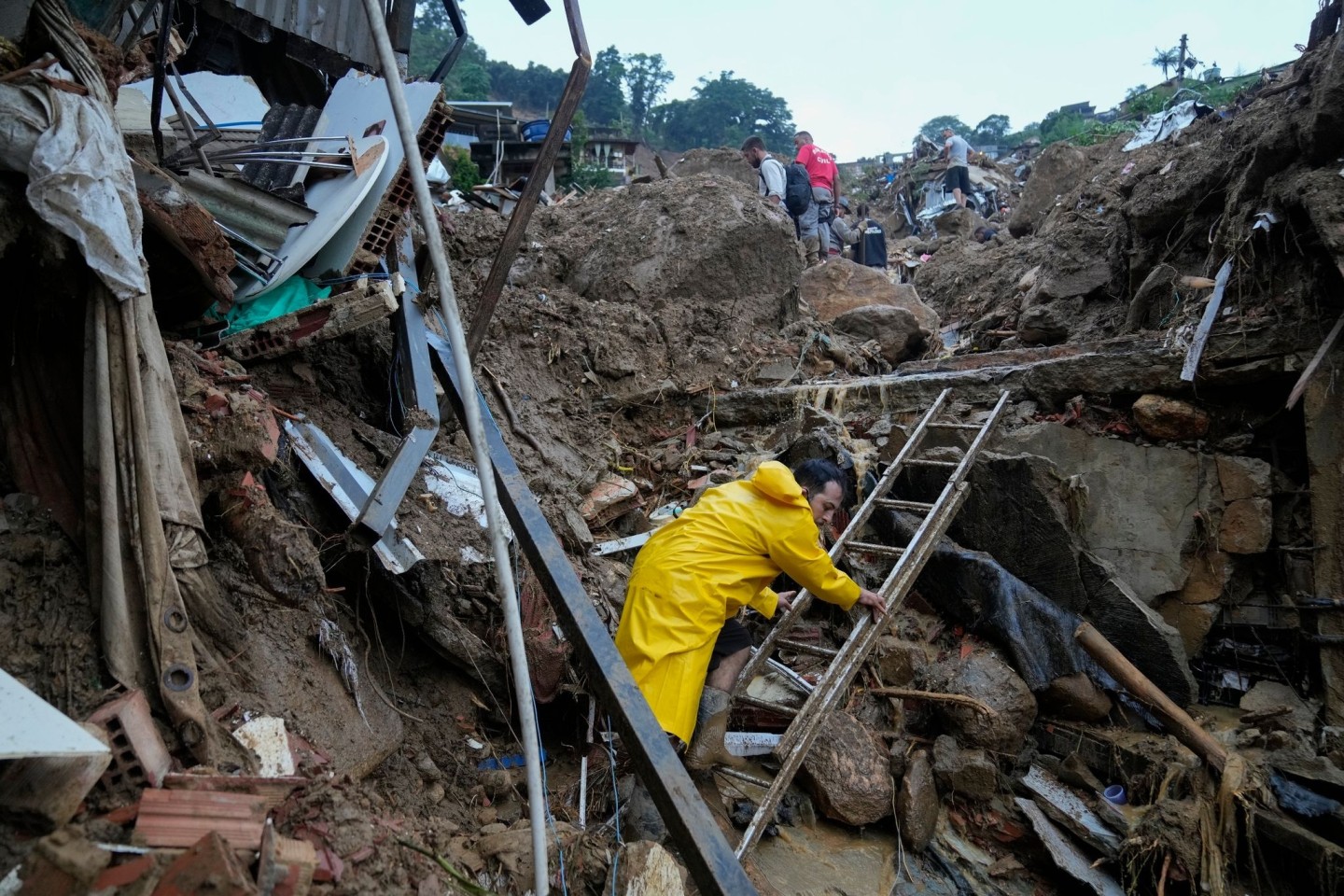 Rettungskräfte und Anwohner suchen nach Opfern in einem von Erdrutschen betroffenen Gebiet in Petrópolis.