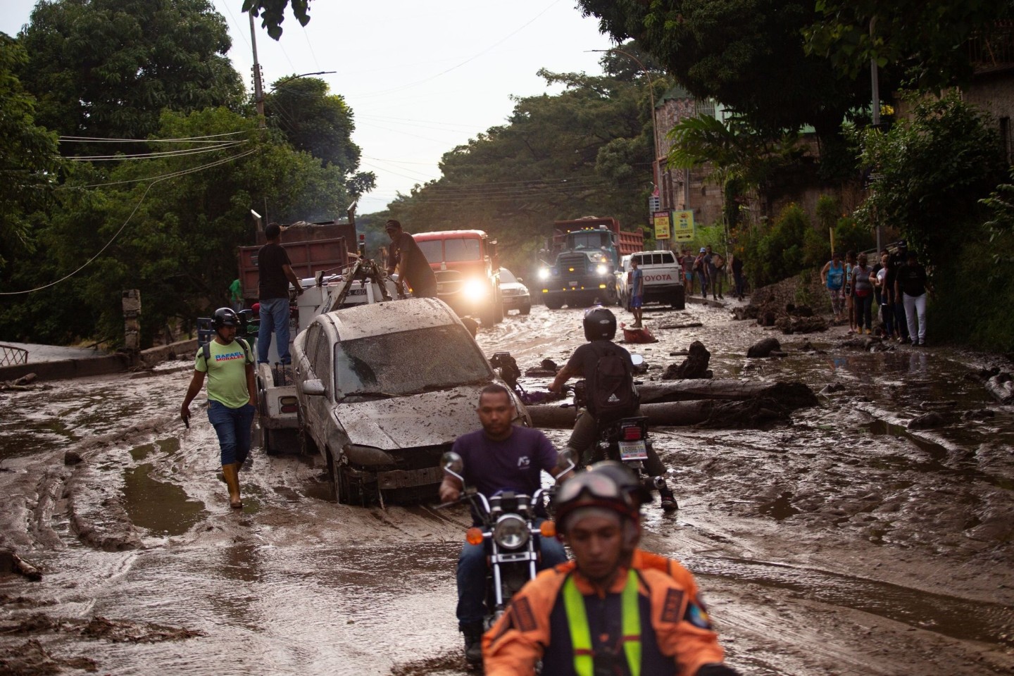 Menschen und Fahrzeuge stecken im Schlamm der durch Überschwemmungen und Erdrutsche auf die Straßen kam. Heftige Regenfälle in Venezuela führten zu Hochwasser in der Stadt Maracay im Bun...