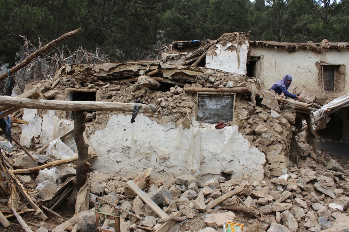 Ein Dorfbewohner sucht in den Trümmern seines Hauses in Chost nach seinen Habseligkeiten.