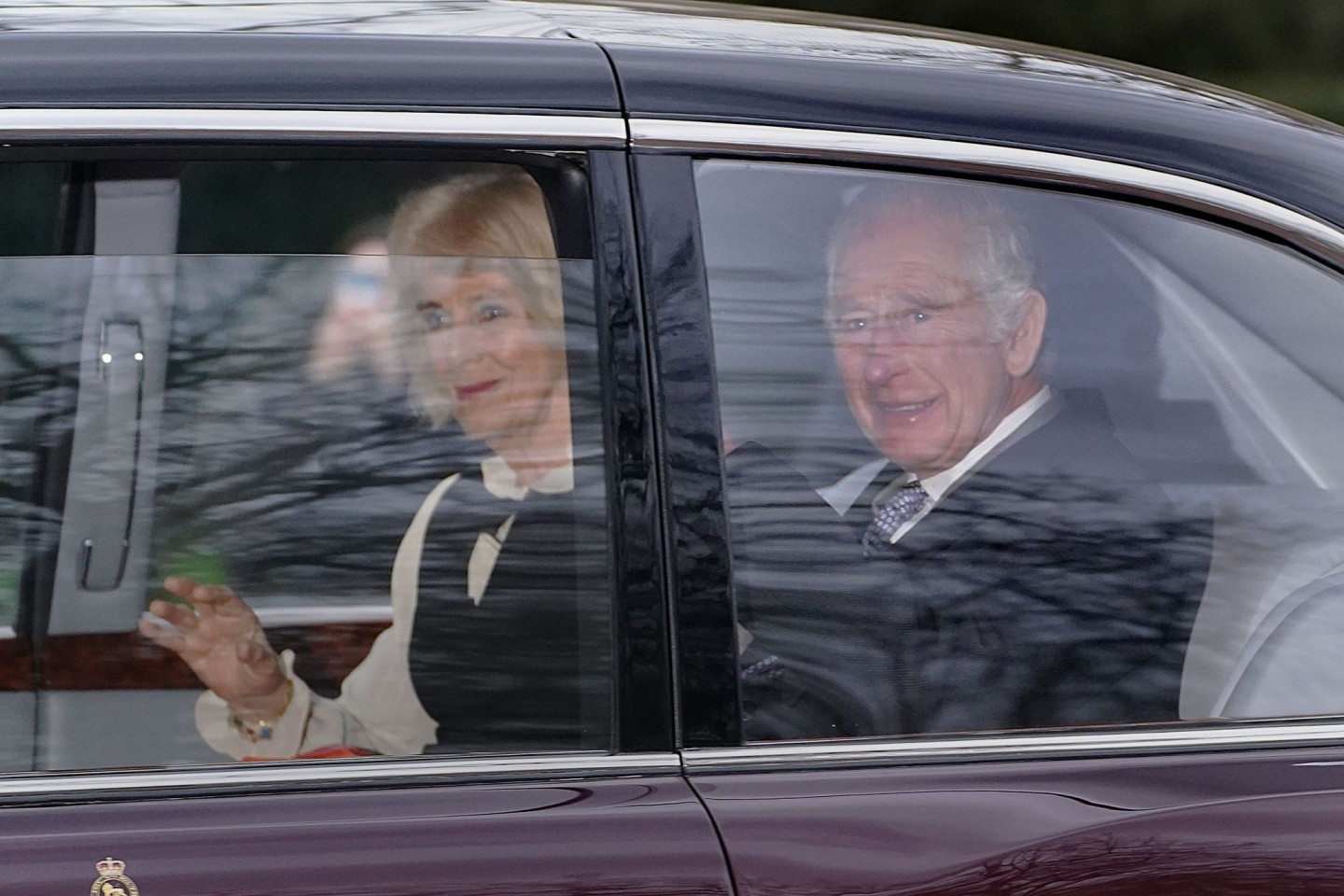 König Charles III. und Königin Camilla verlassen in einer Limousine das Clarence House in London.