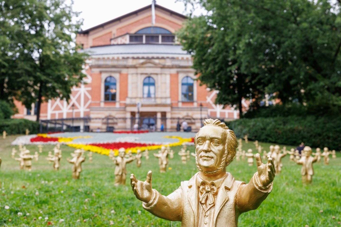 Goldfarbene Wagner-Figuren des Konzeptkünstler Ottmar Hörl stehen im Rahmen der Kunstinstallation «You're welcome» vor dem Festspielhaus.