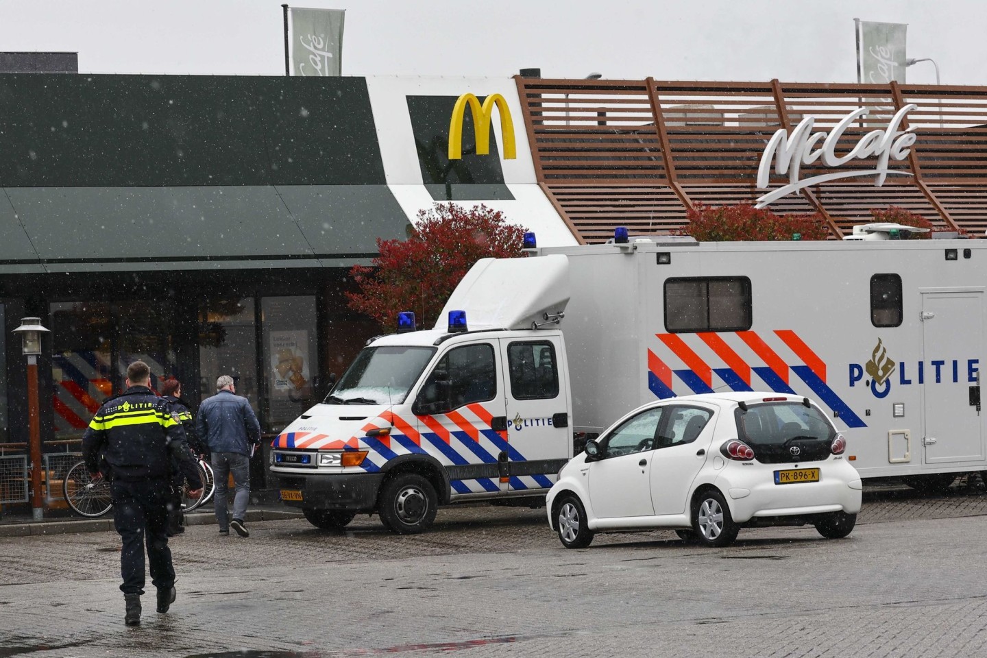 Polizisten ermittelt am Tatort, wo zwei Männer nach Schüssen in einem Schnellrestaurant ums Leben gekommen sind.