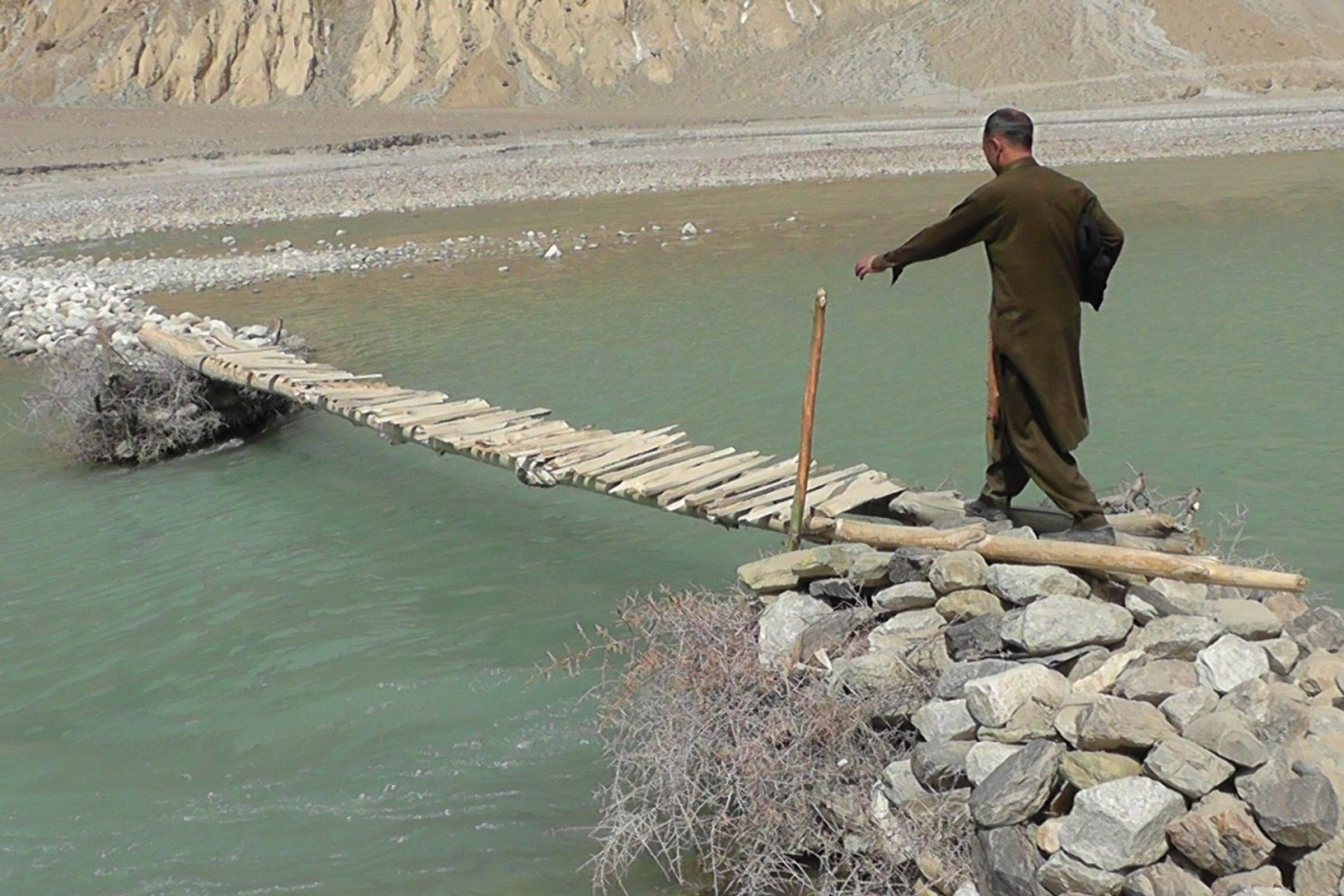 Ein Mann geht über eine hölzerne Brücke im Norden Pakistans nahe der afghanischen Grenze. Sturzfluten im hatten im vergangenen Jahr eine Brücke weggespült.