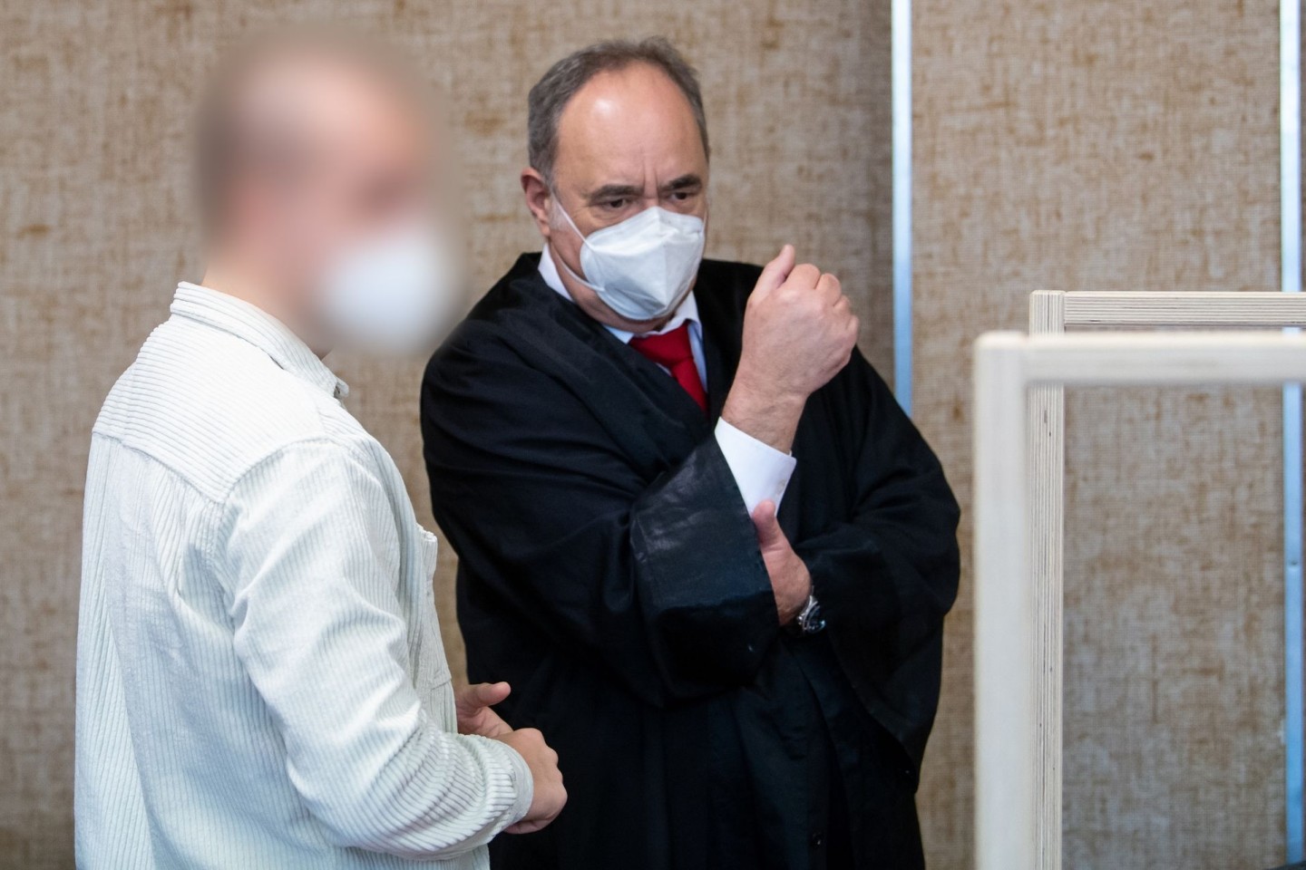 Der angeklagte Polizist (l) mit seinem Anwalt im Verhandlungssaal. Der Mann wurde zu einer Geldstrafe von 13.200 Euro verurteilt.