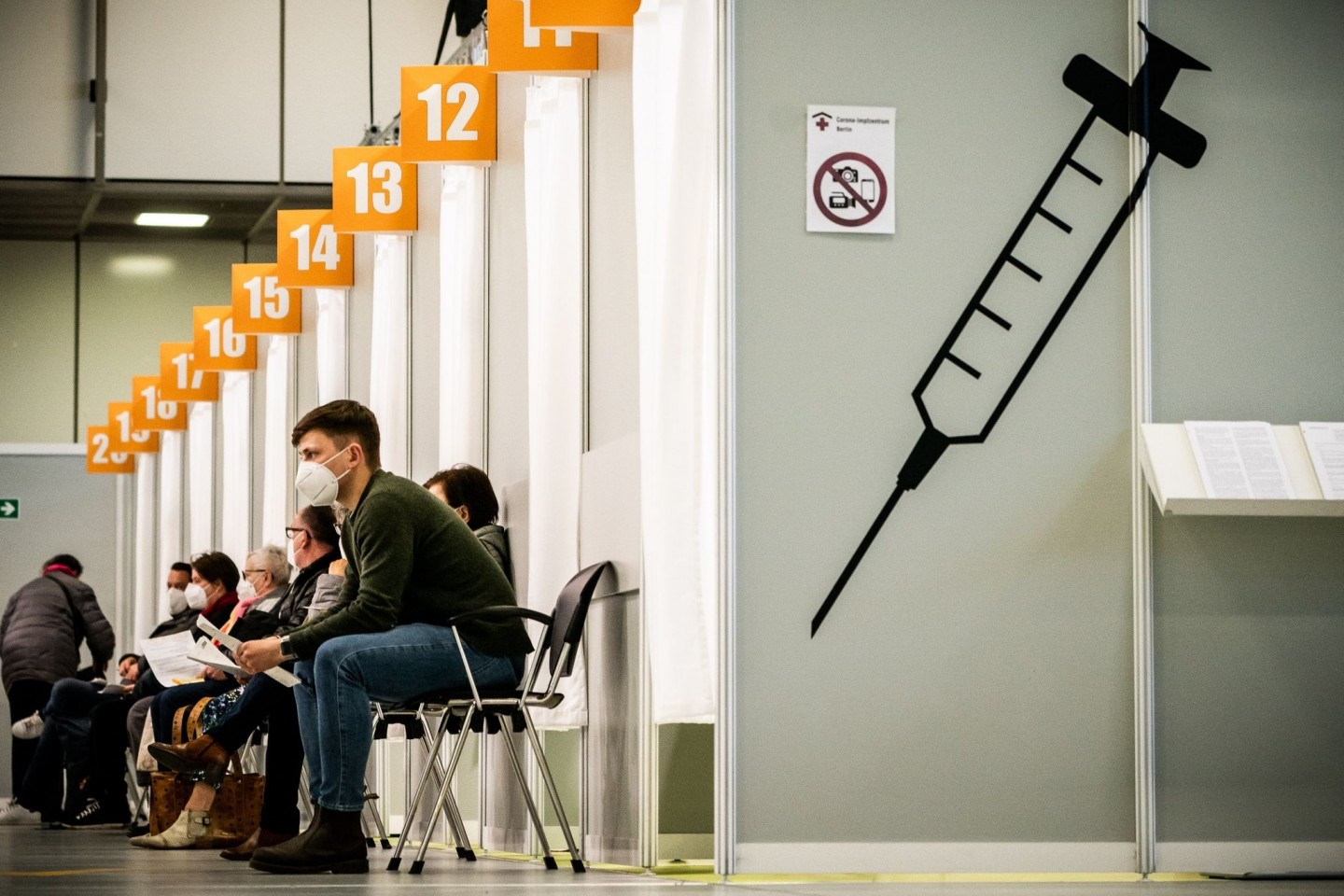 Menschen warten im Corona-Impfzentrum auf dem Messegelände Berlin auf ihre Impfung.
