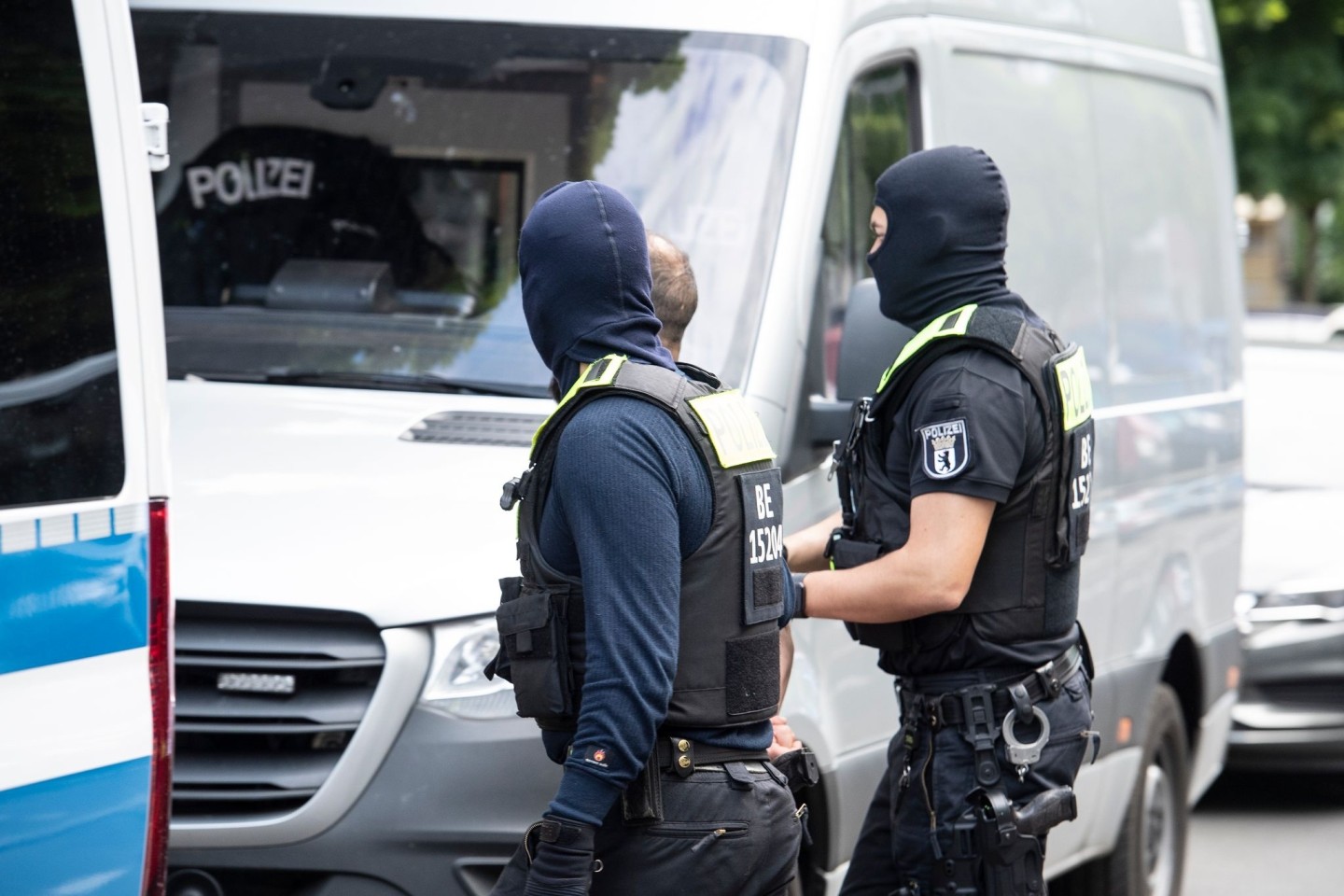 Polizisten führen einen Mann ab. Mit einer Razzia ist die Polizei in Berlin gegen den organisierten Drogenhandel vorgegangen.