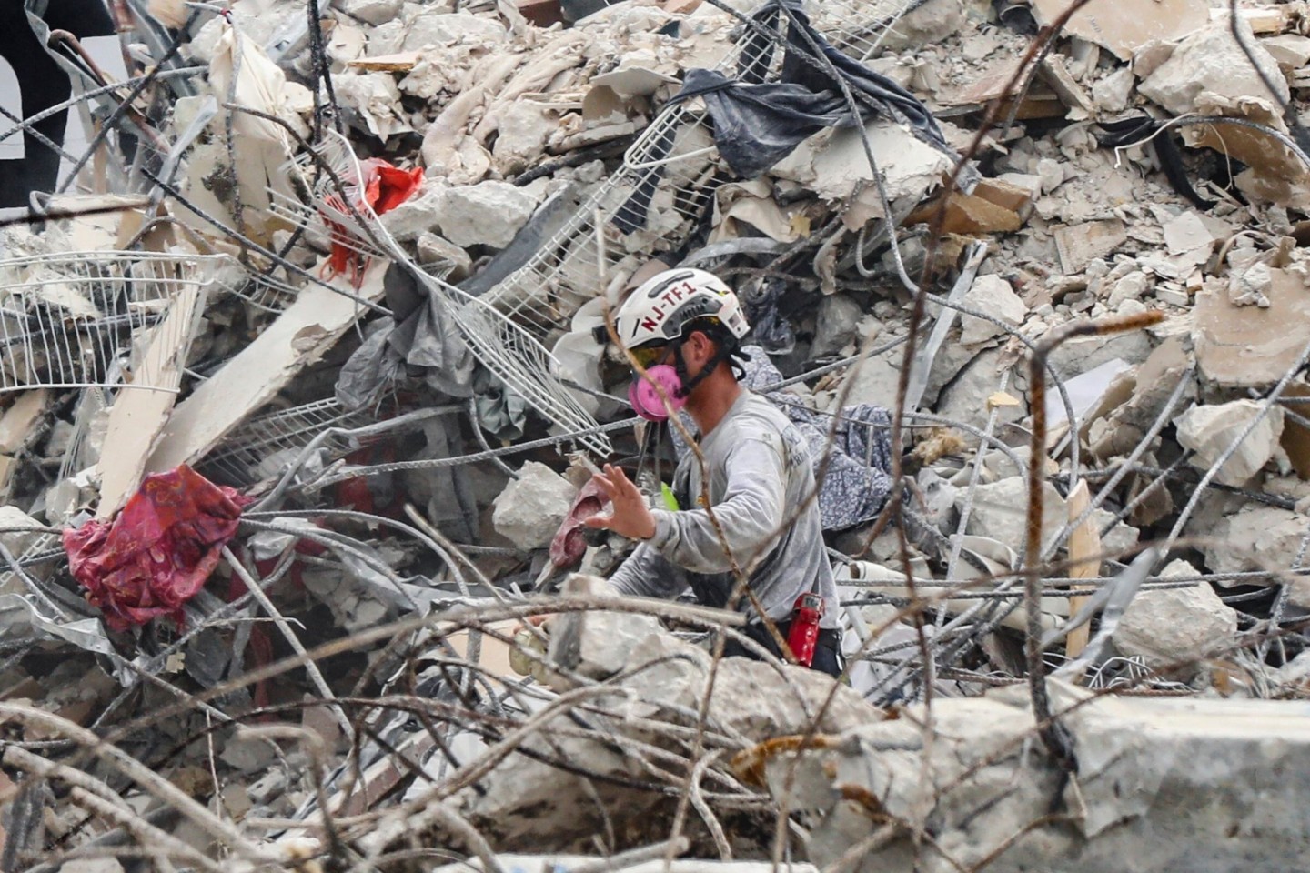 Rettungskräfte arbeiten sich durch die Trümmern des teilweise eingestürzten Wohnkomplexes.
