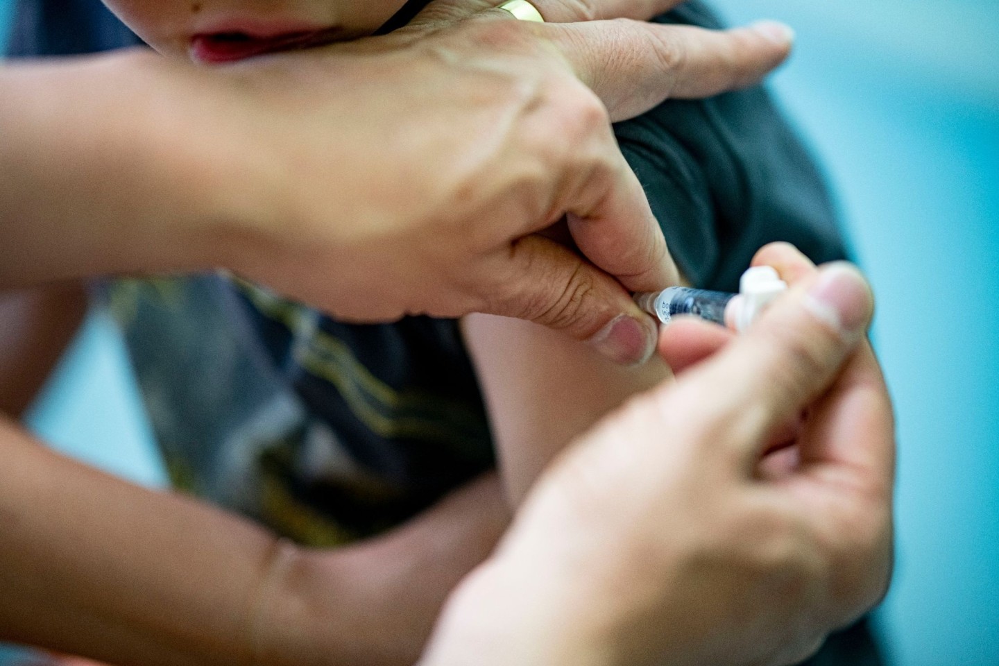 Ein Kinderarzt verabreicht einem Jungen einem Auffrischung eines DTP-Kombinationsimpfstoff.