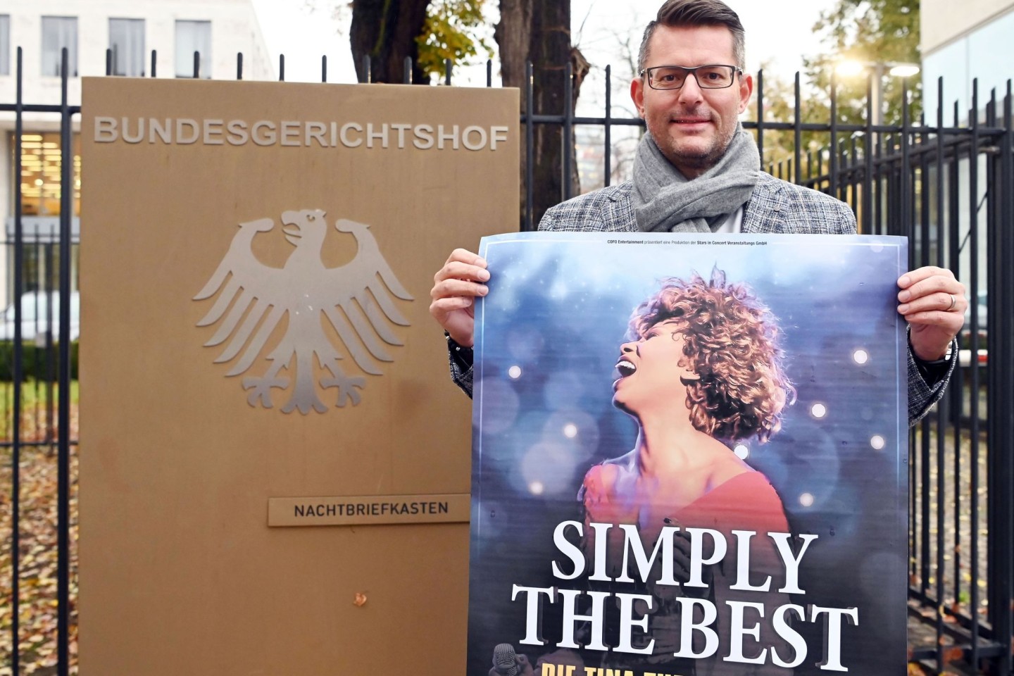 Tourneeveranstalter Oliver Forster vor dem Bundesgerichtshof (BGH) mit Plakat der Show „Simply The Best - Die Tina Turner Story“.