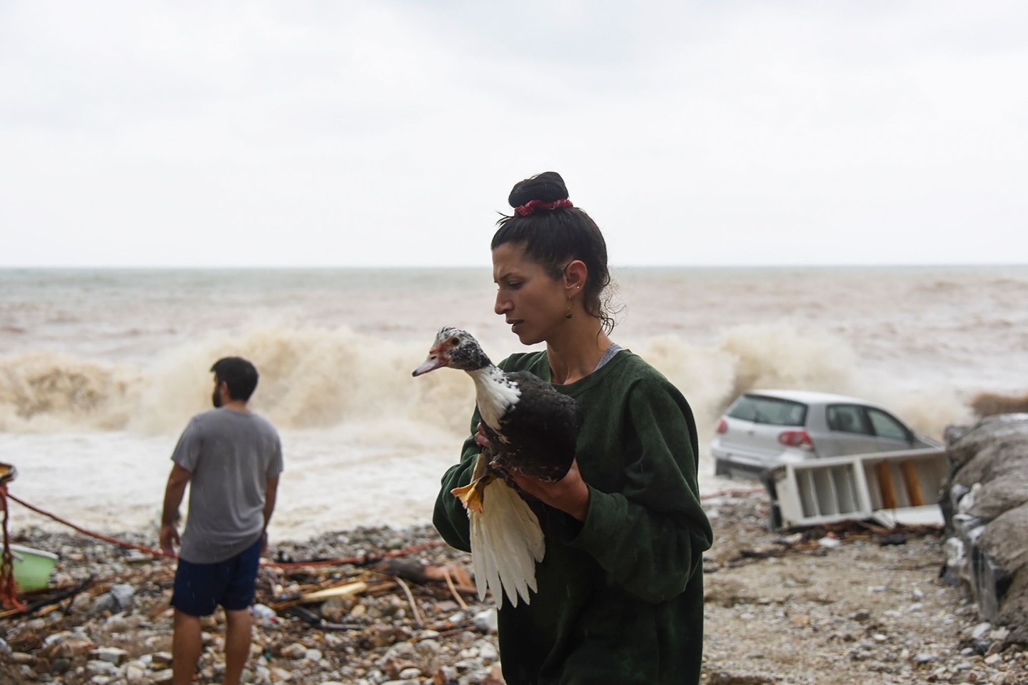Eine Frau rettet nach dem schweren Sturm einen Vogel am Strand des Dorfes Paliokastro auf Kreta.