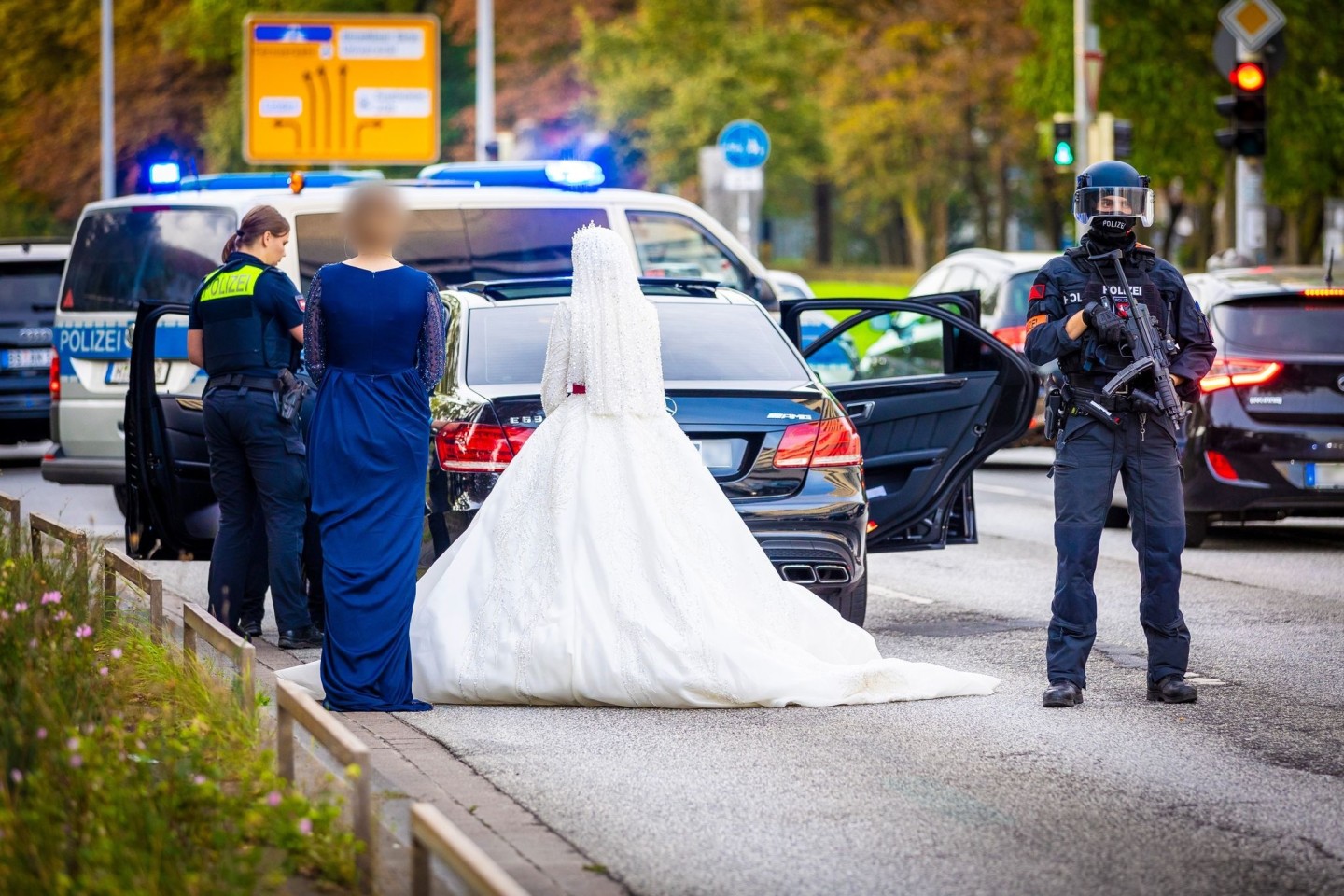 Polizisten kontrollieren Teilnehmer eines Hochzeitskorsos und ihre Fahrzeuge.