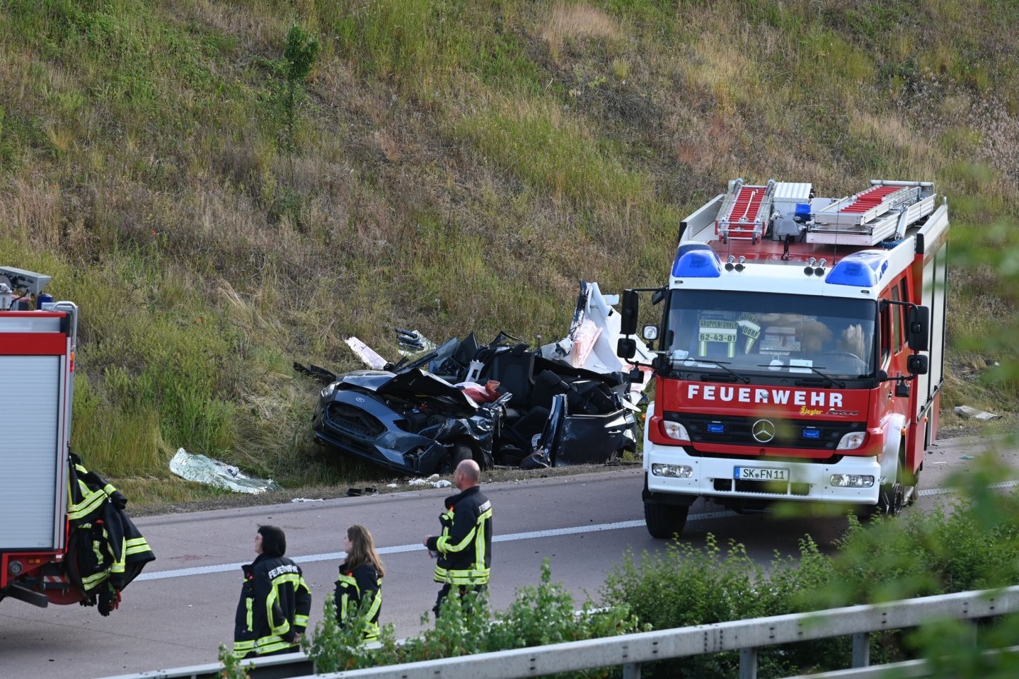 Einsatzkräfte der Feuerwehr an der Unfallstelle auf der Autobahn 14 bei Halle.