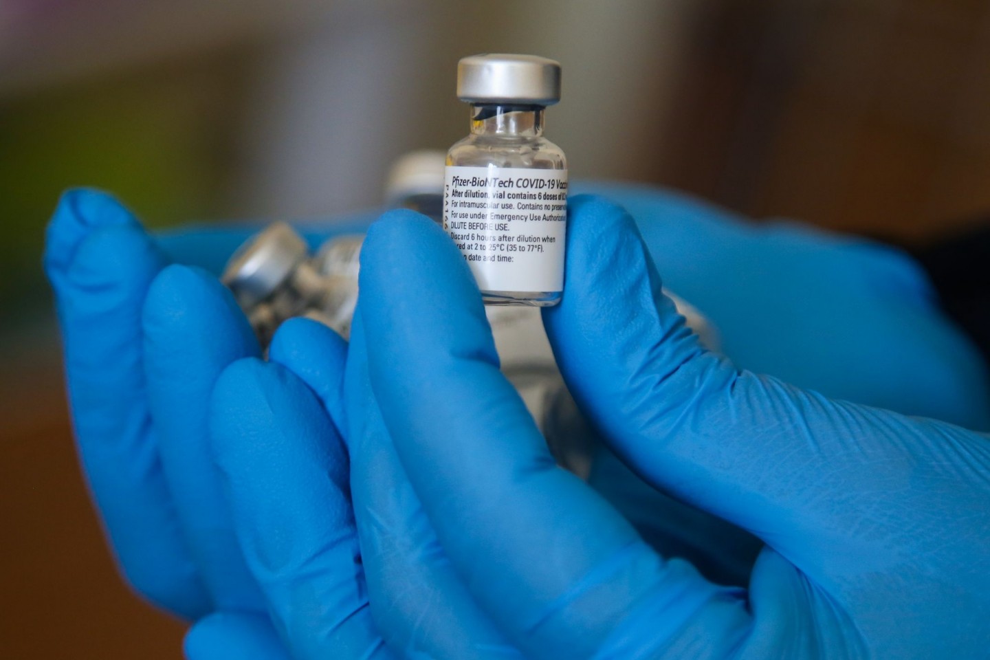 Ein Impfarzt hält einen Behälter mit dem Impfstoff gegen Covid-19 von Pfizer in einem Impfzentrum während der Impfung.