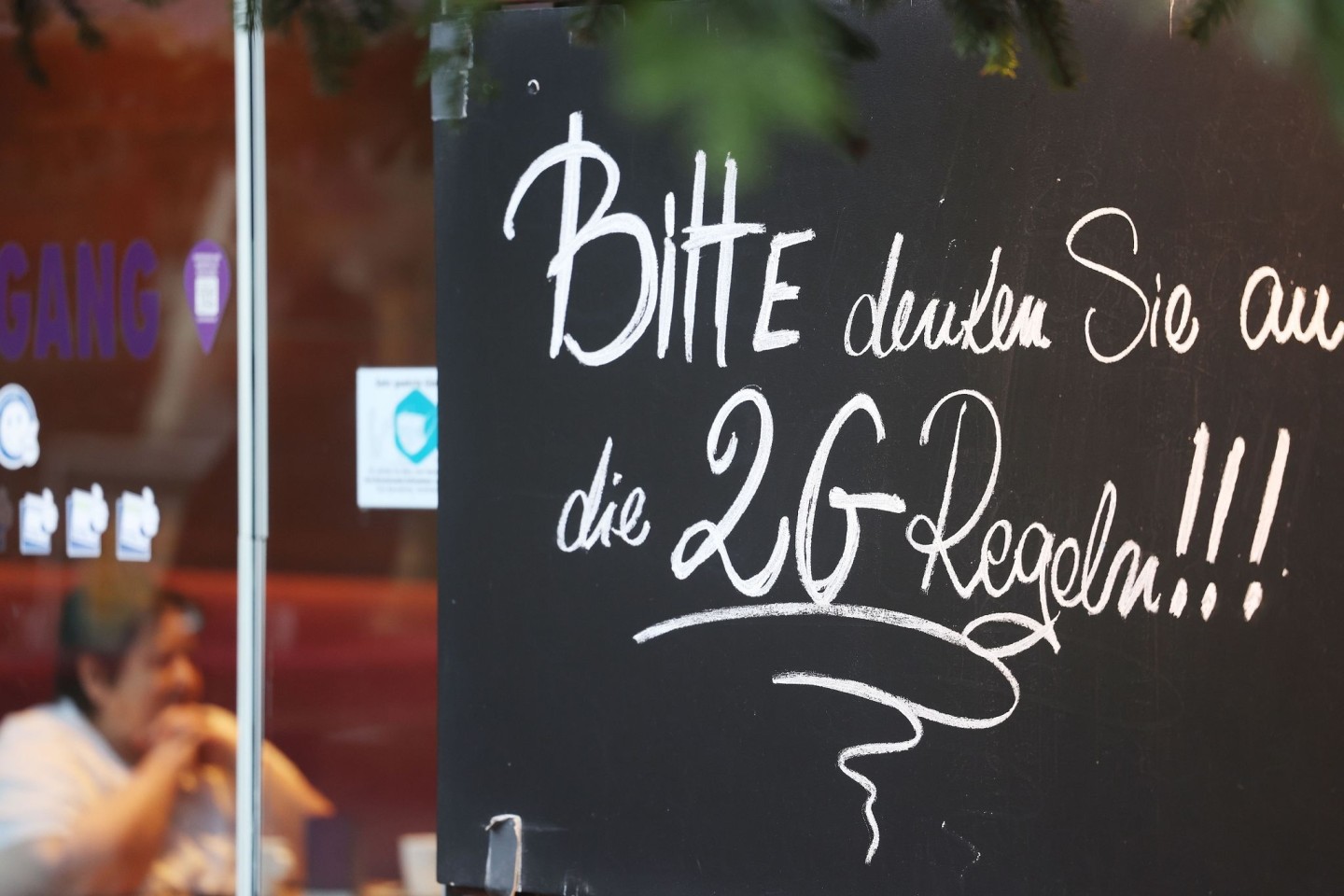 Ein Schild, das auf die 2G-Regeln hinweist, an einem Café in Bonn.