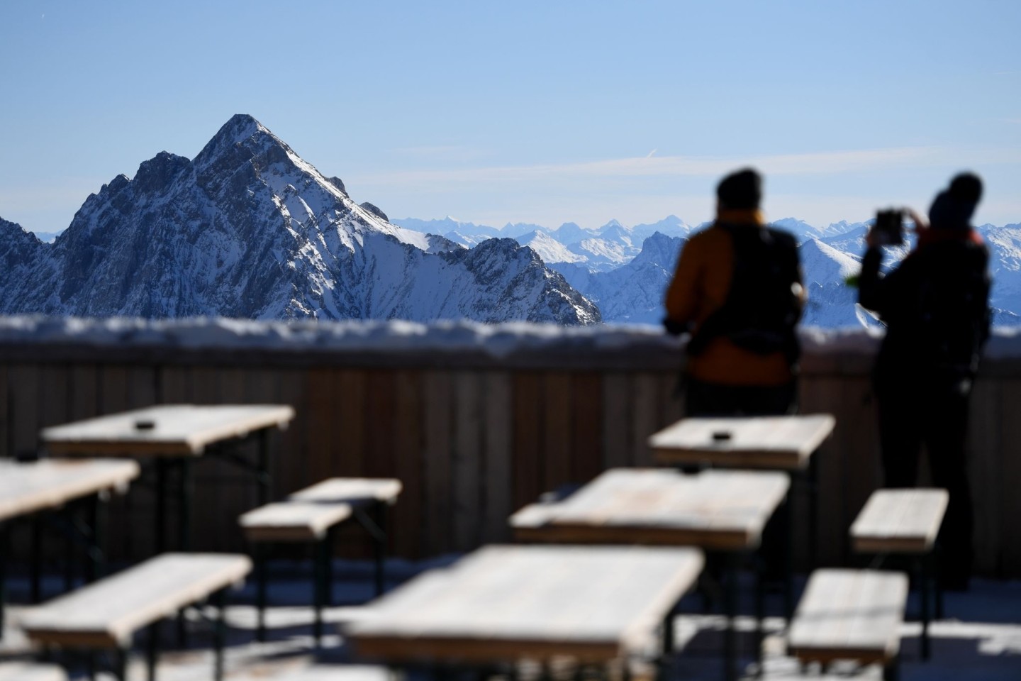 Zwei Besucher fotografieren von der Zugspitze aus das Panorama des Wettersteingebirges. Nach gut eineinhalbjähriger Pause wegen Corona sollen dort wieder Lifte laufen und Skifahrer ihre Sch...
