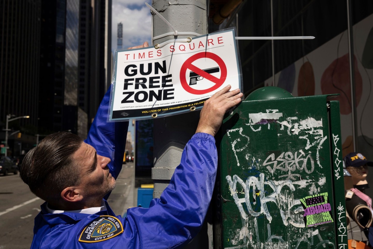 Ein New Yorker Polizist befestigt ein Schild mit der Aufschrift «Gun Free Zone» (Waffenfreie Zone).