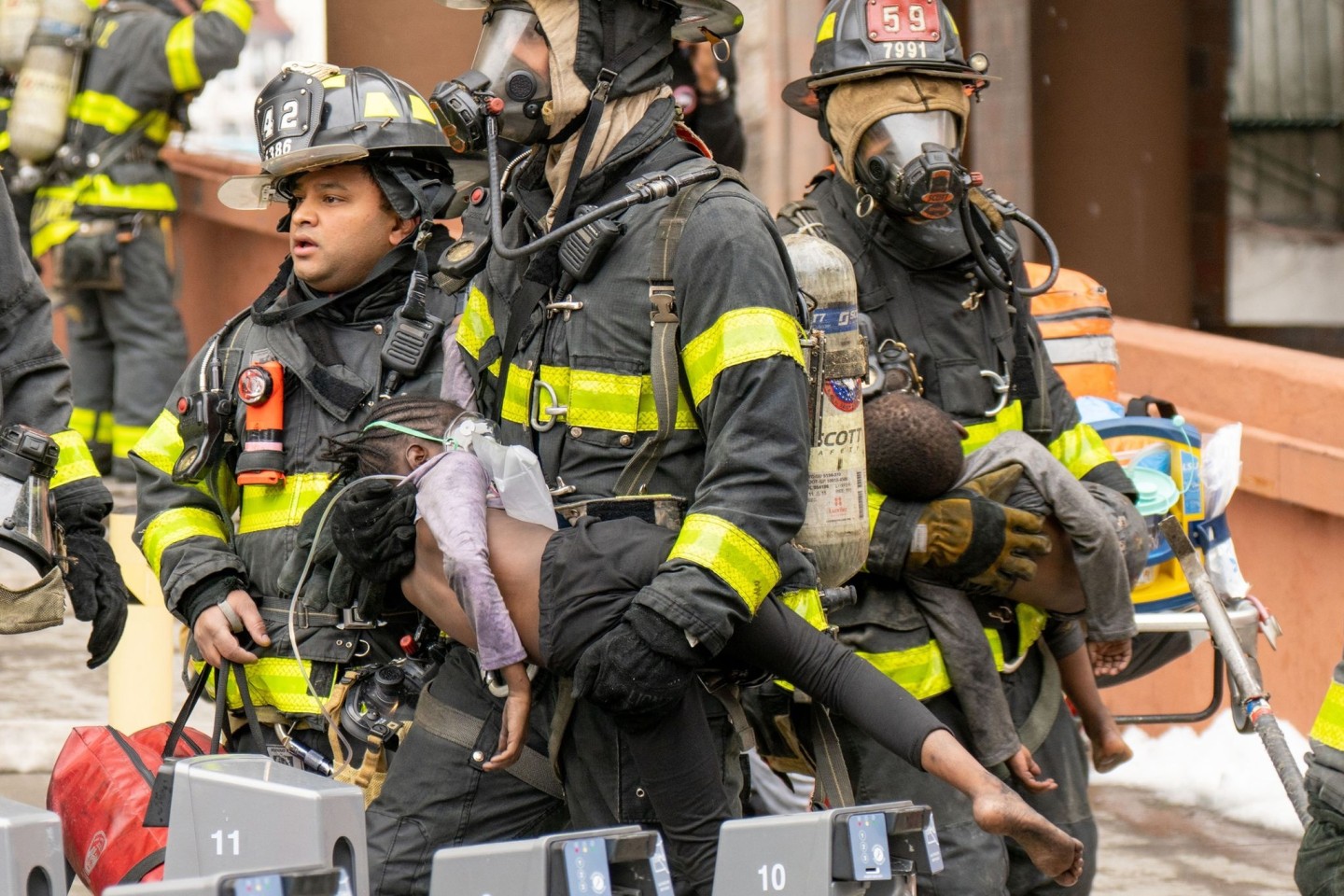 Feuerwehrleute tragen Kinder aus einem Wohnhaus in der Bronx. Bei dem Feuer sind nach Angaben des Bürgermeisters Adams 17 Menschen getötet worden.
