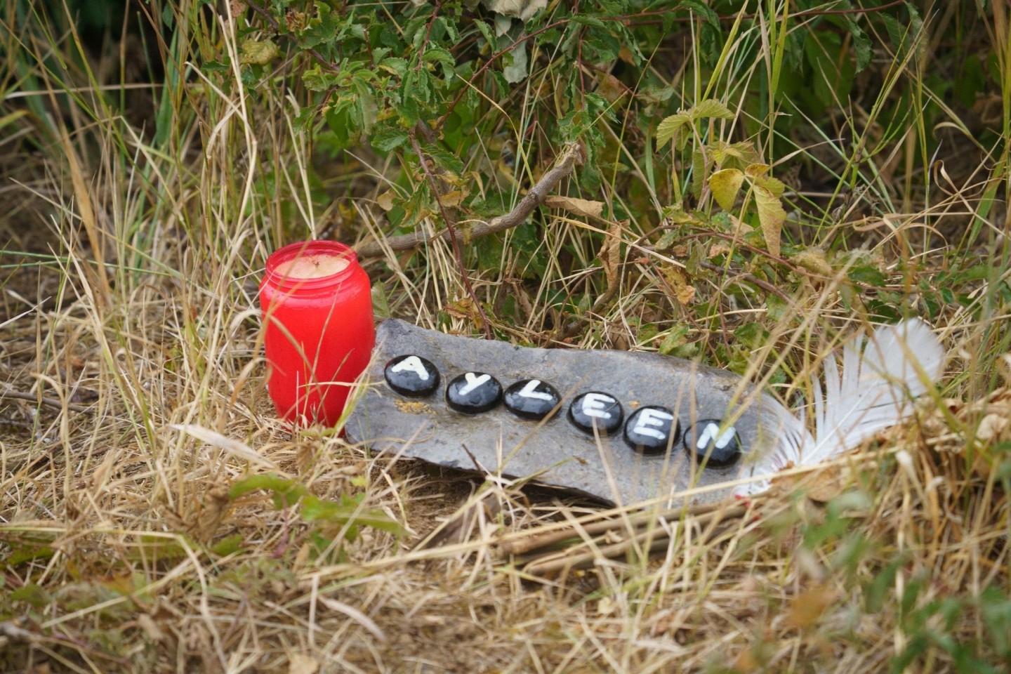 Eine Kerze und eine Tafel mit dem Namen Ayleen am Ufer des Teufelsees, wo die Leiche der 14-Jährigen gefunden wurde.