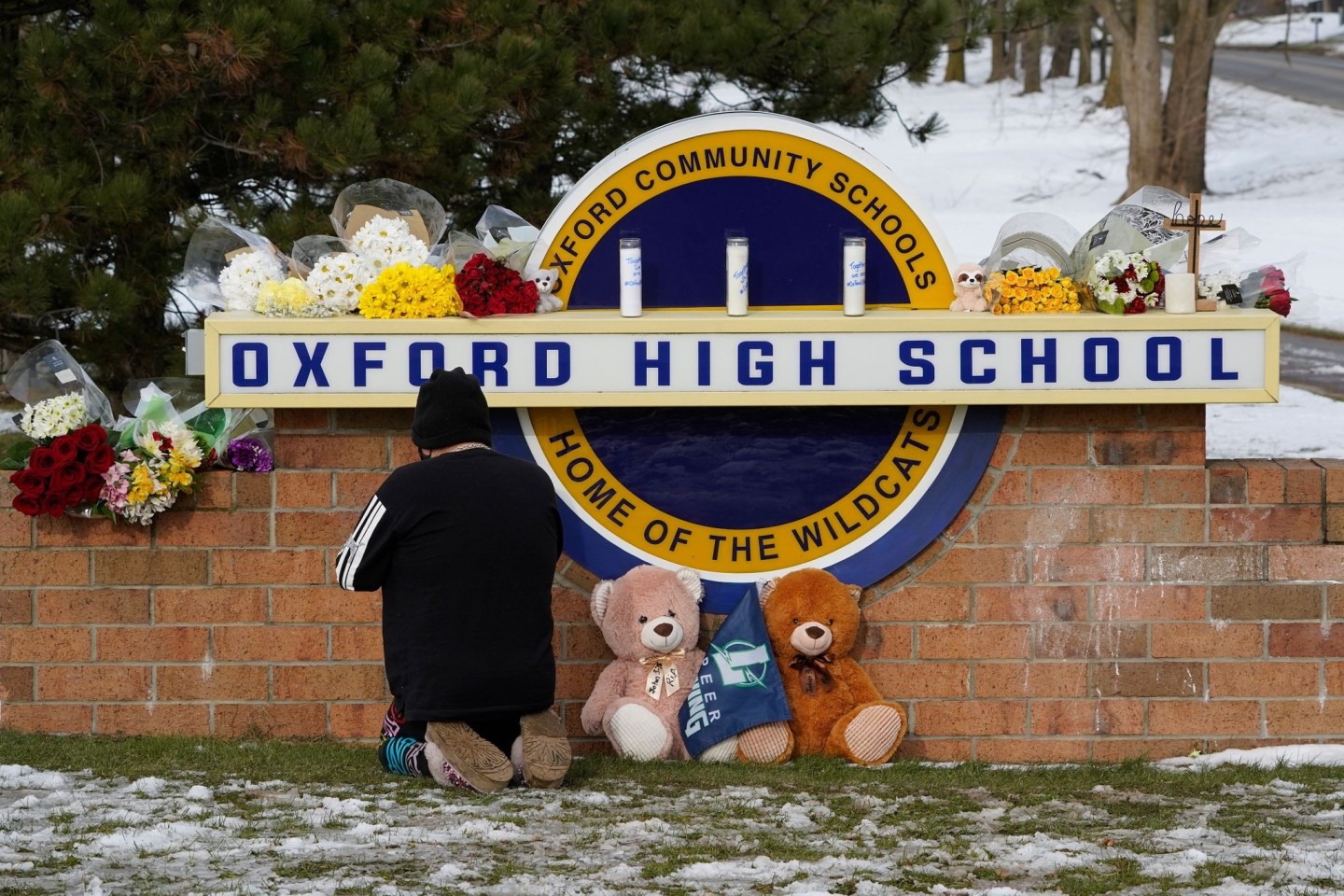 Eine Frau kniet zum Gebet vor dem Schild der Oxford High School im US-Bundesstaat Michigan. Ein 15-Jähriger hat dort mindestens vier seiner Mitschüler getötet.