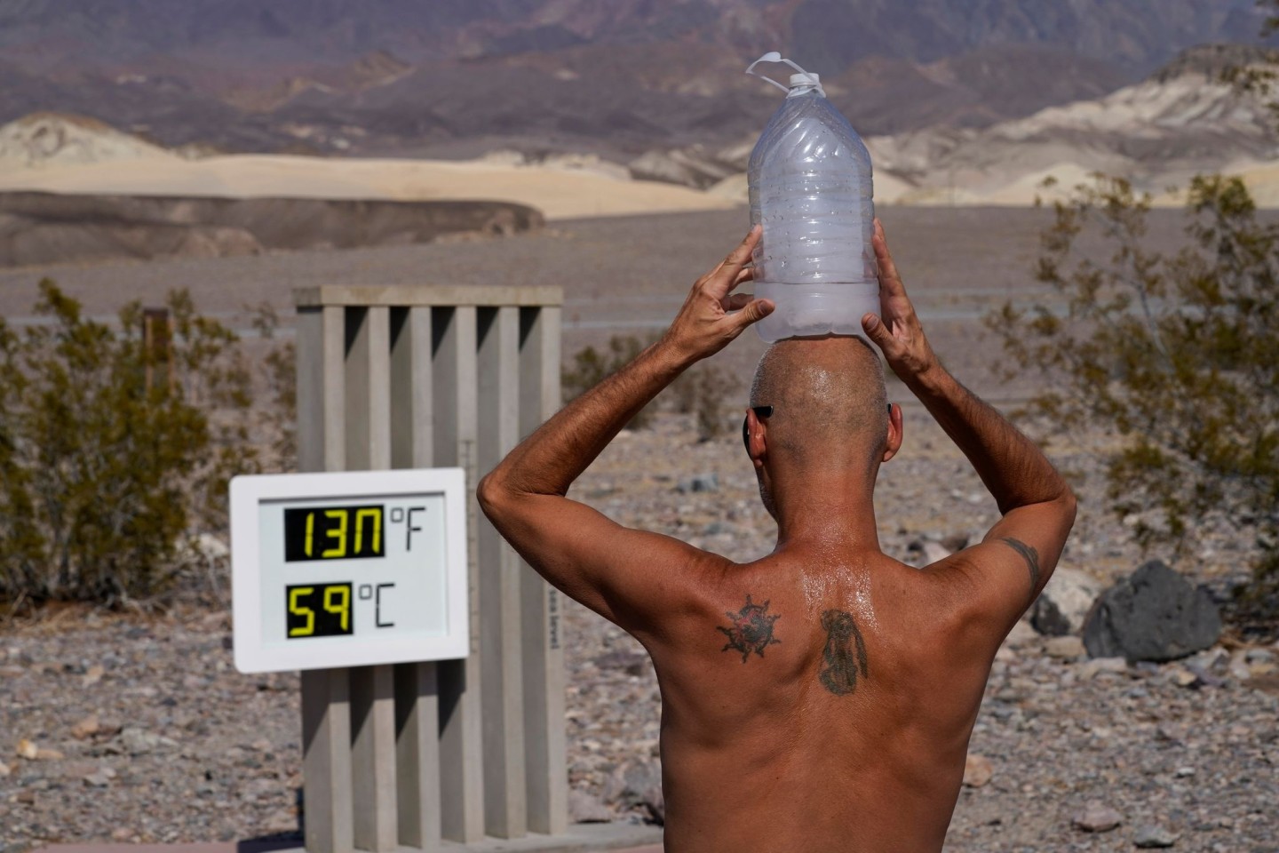 Ein Mann kühlt sich im «Death Valley»-Nationalpark mit einer mit Eiswasser gefüllten Plastikflasche auf dem Kopf ab.