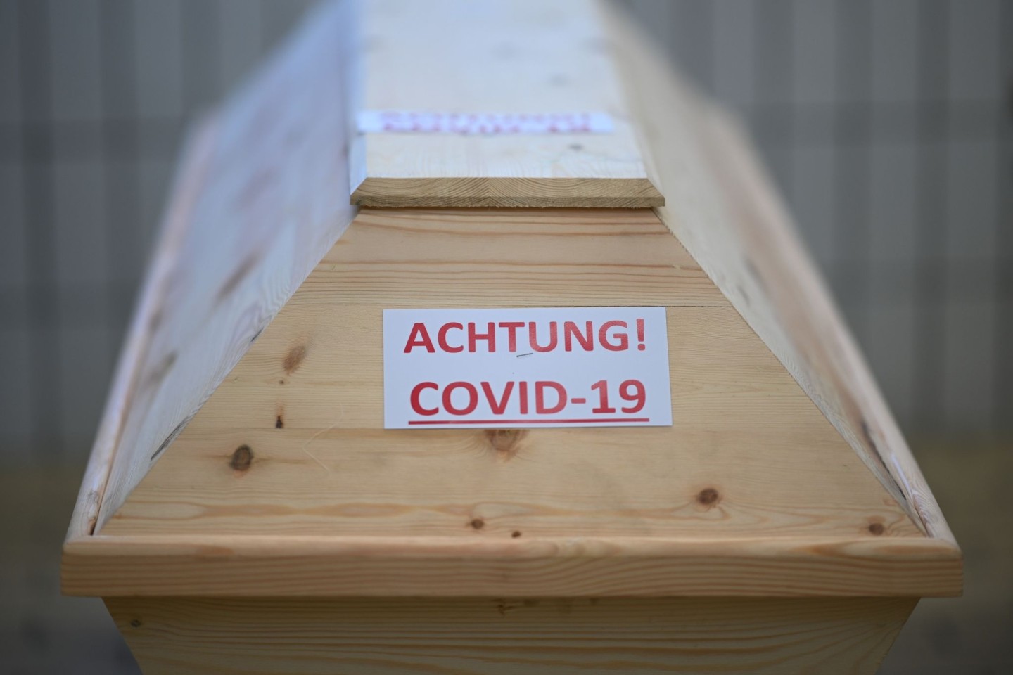 Ein Sarg mit der Aufschrift «Achtung! Covid-19» in einem Raum im Krematorium, bevor der Sarg eingeäschert wird.