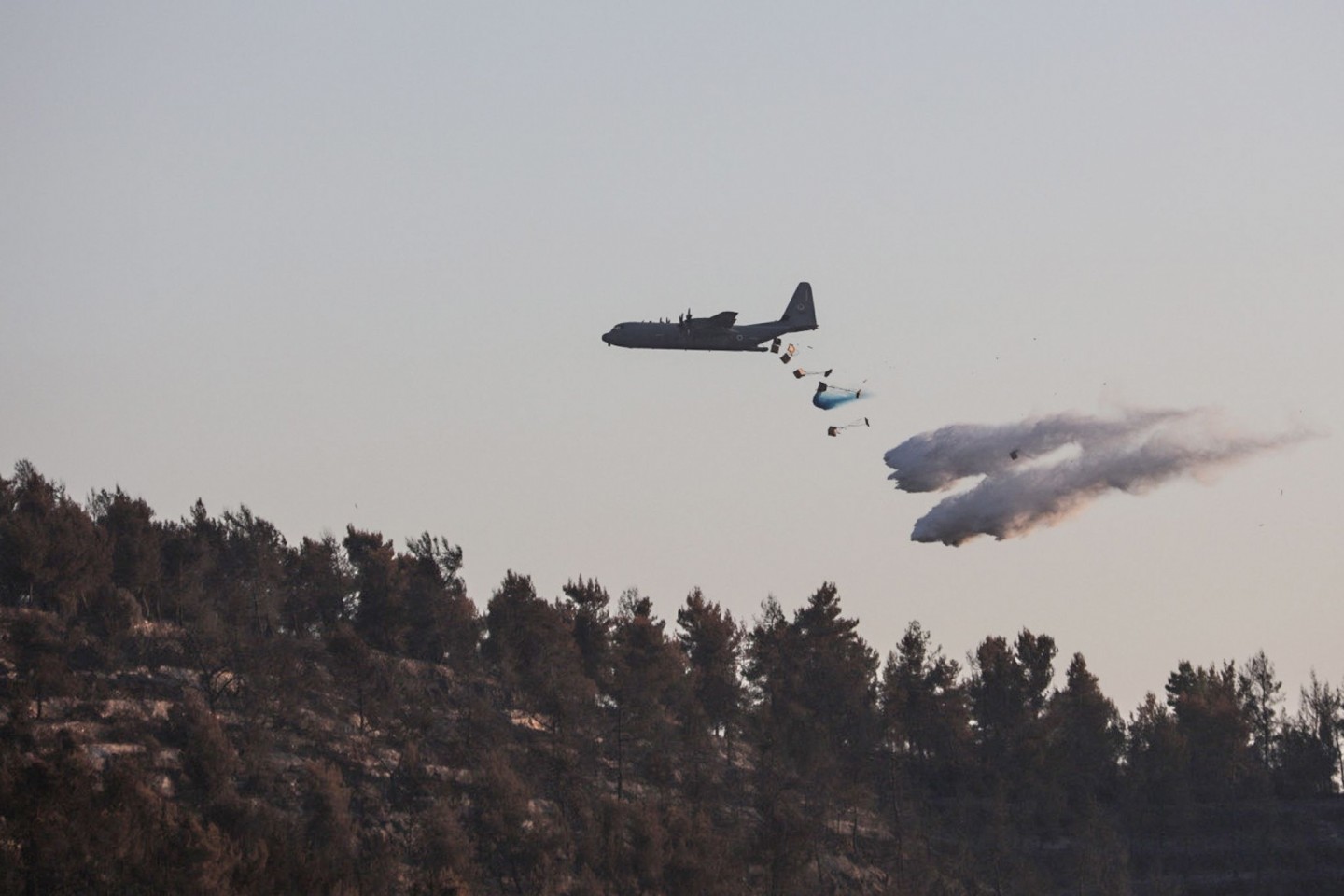 Eine Lockheed C-130 Hercules wirft Löschmittel auf einen Waldbrand westlich von Jerusalem.