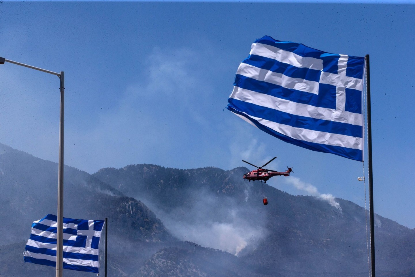Archivbild: Ein Hubschrauber arbeitet Ende Mai an der Eindämmung eines Waldbrandes in Griechenland. In dem Land sind erneut mehrere Brände ausgebrochen.