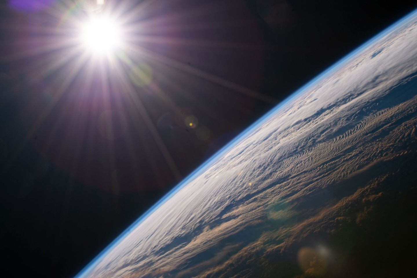Die Sonne scheint über dem Horizont der Erde, während die Internationale Raumstation über der kanadischen Provinz Quebec kreist.