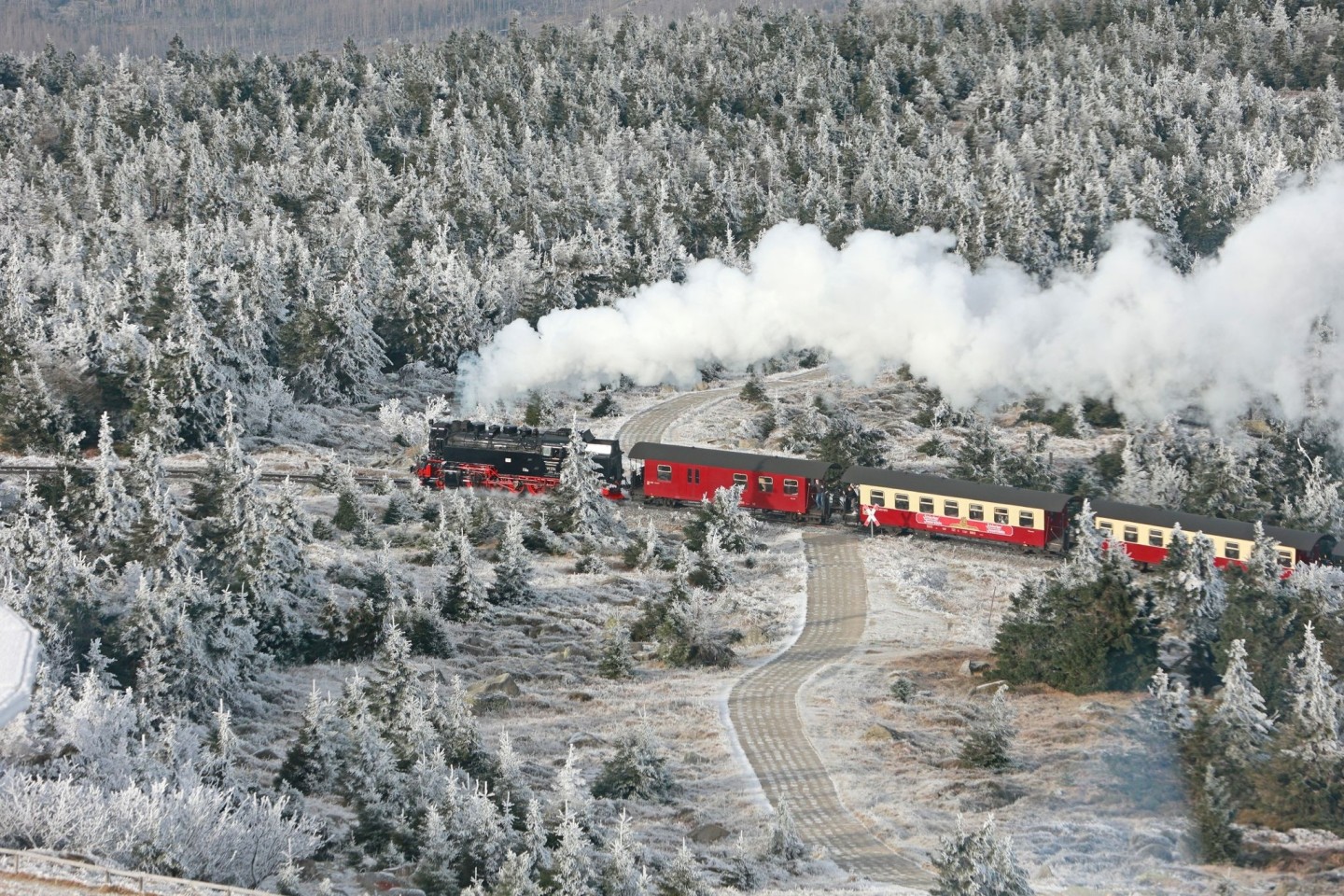 Idyllisch: Ein Zug der Harzer Schmalspurbahnen fährt durch den mit Raureif bedeckten Brockenwald.