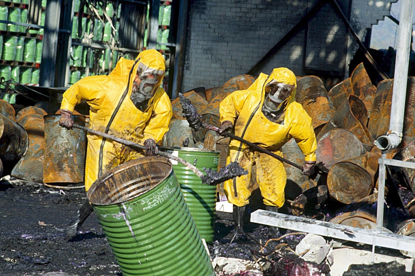 Feuerwehrleute in Schutzkleidung räumen einige Tage nach dem Brand im Chemiewerk des Schweizer Chemieunternehmens Sandoz die Trümmer auf.