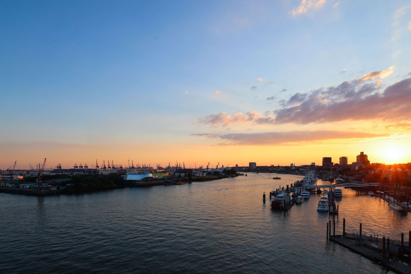 Die Sonne geht über der Elbe und dem Hamburger Hafen unter.